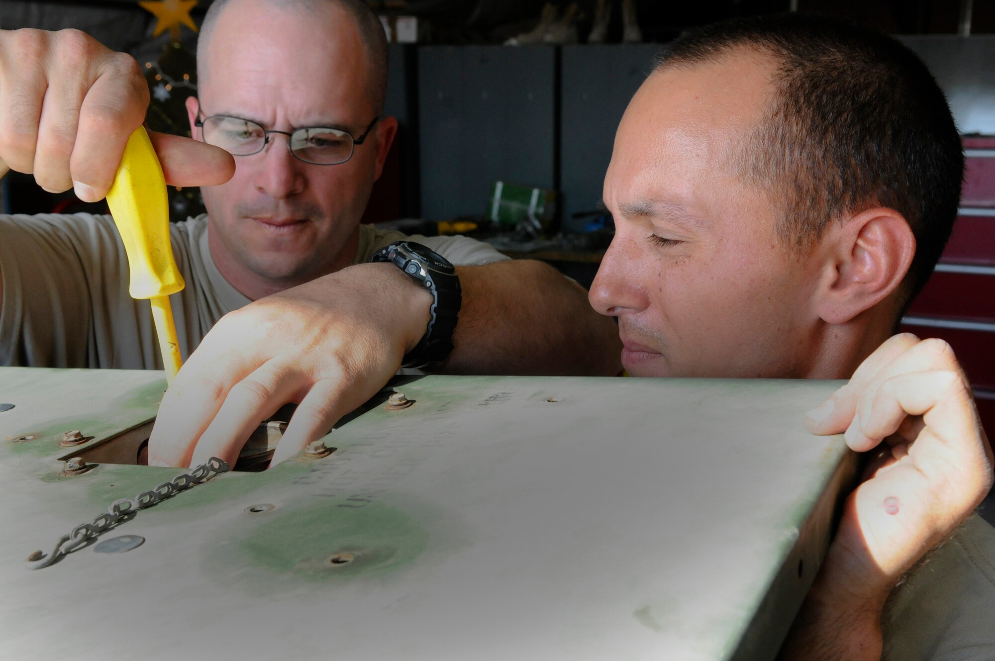Tech. Sgt. Andrew Ferguson tightens a connection while Senior Airman Craig Stawicki holds the top in place Dec. 30, 2008, at an undisclosed location in Southwest Asia. The maintainers, Electrical Power Plant Production technicians assigned to the 71st Expeditionary Air Control Squadron, are responsible for servicing the generators that keep the 71 EACS radars up and running. Sergeant Ferguson is a native of Colt, Ark., and Airman Stawicki hails from Brick, N.J. (U.S. Air Force photo by Tech. Sgt. Michael Boquette)