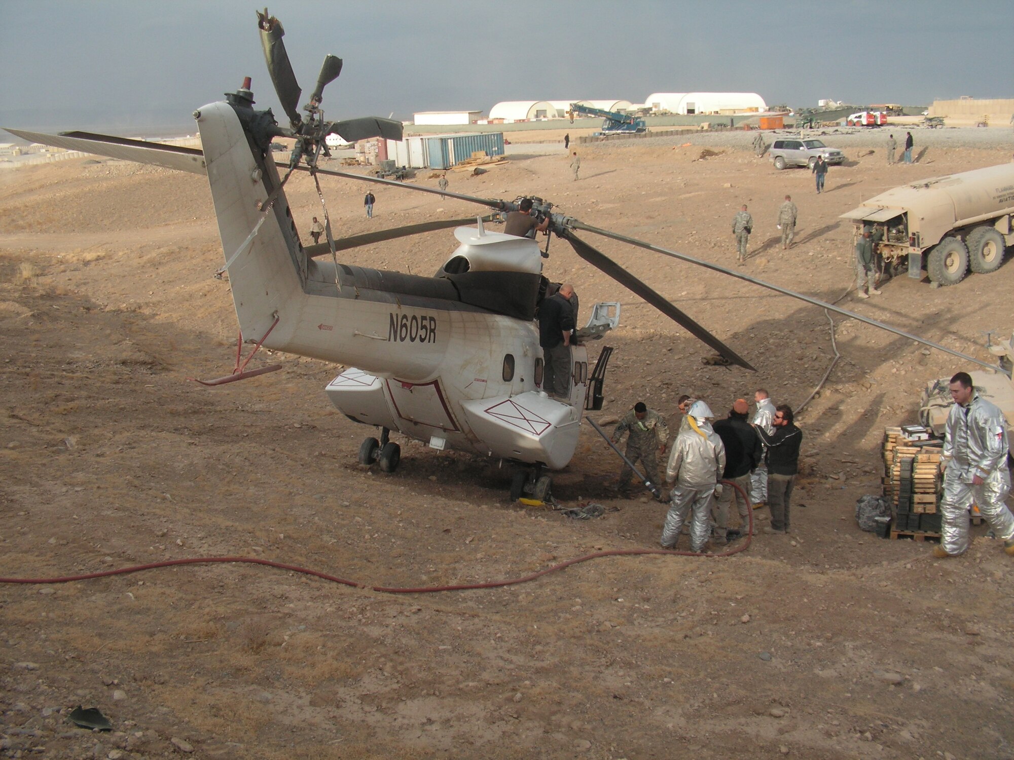 Emergency response workers and forward operating base personnel prepare a helicopter for removal after it crashed in a ditch Dec. 15, 2008. Firefighters forward deployed from the 379th Expeditionary Civil Engineer Squadron were the first on scene.  (Courtesy photo)