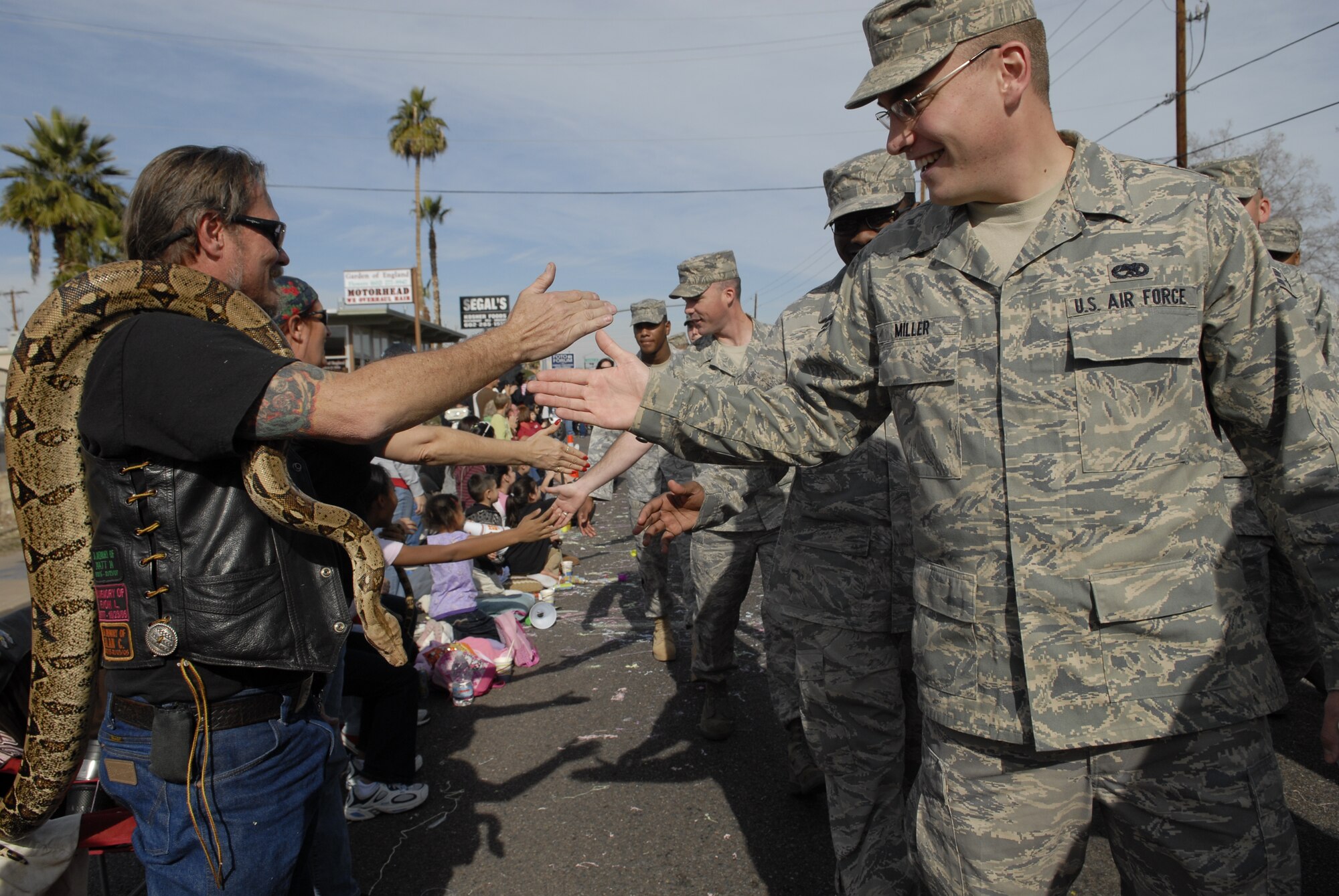 A Luke Air Force Base Airman gives a high-five to an on-looker as a group of Airmen walks through downtown Phoenix during the 38th Annual Fiesta Bowl Parade Jan. 3. More than 100 Airmen participated in the event which is part of Phoenix's Fiesta Bowl event schedule including the Insight Bowl game in Tempe, for which Luke F-16s performed a fly-over and the Fiesta Bowl game itself in which Luke Airmen will be honored. (U.S. Air Force photo/Master Sgt. William Gomez)
