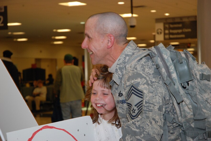 Chief Master Sgt. Jeffrey Cain, 22nd Air Force, hugs daughter Ella Grace after arriving to the Atlanta Hartsfield-Jackson Airport Jan. 5. Chief Cain along with five other Security Forces Airmen returned home Jan. 5 from a six-month deployment to Southwest Asia in support of Operation Iraqi Freedom. The reserve Airmen defended their base through gate checks and random anti-terrorism measures. (U.S. Air Force photo/Master Sgt. Stan Coleman)
