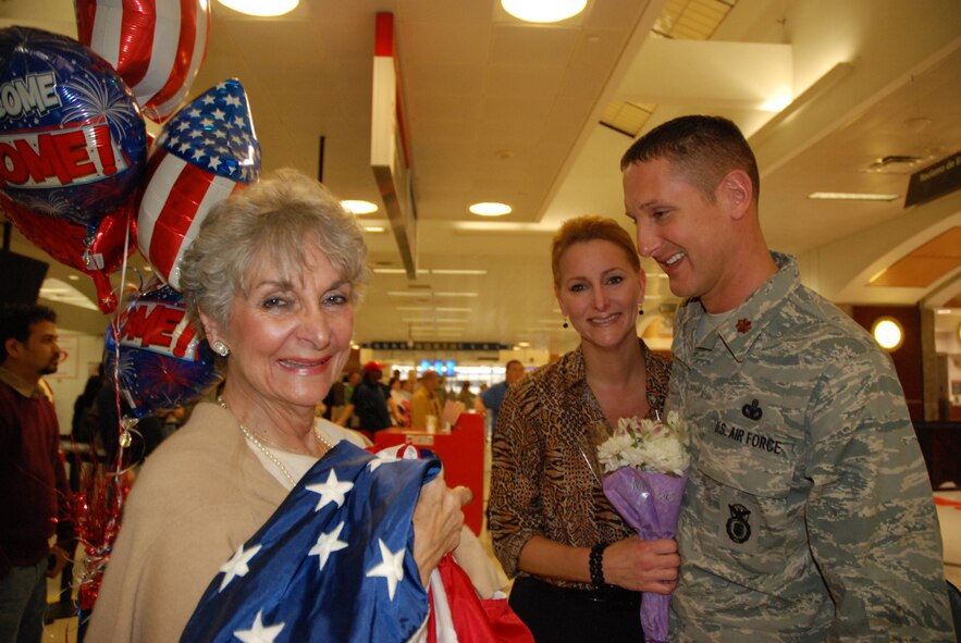Maj. Dave Guio, 94th Security Forces Squadron, greets his girlfriend, Vanessa Sharp, and her mother, Jo Sargent at the Atlanta Hartsfield-Jackson Jan. 5. Major Guio and five other Security Forces Airmen returned home Jan. 5 from a six-month deployment to Southwest Asia in support of Operation Iraqi Freedom. The reserve Airmen defended their base through gate checks and random anti-terrorism measures.  "The holidays were horrible without him," said Ms. Sharp. (U.S. Air Force photo/Master Sgt. Stan Coleman)