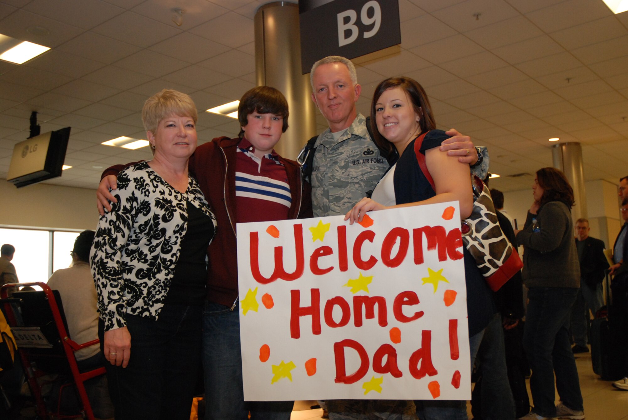 Chief Master Sgt. Wendell Peacock, 94th Security Forces Squadron, takes a photo with his family - wife, Janet, son, Andrew and daughter, Meagan - at the Atlanta Hartsfield-Jackson Airport Jan. 5. Chief Peacock and five other Security Forces Airmen returned home Jan. 5 from a six-month deployment to Southwest Asia in support of Operation Iraqi Freedom. The reserve Airmen defended their base through gate checks and random anti-terrorism measures. Chief Peacock said the deployment was hard because he missed his 25th wedding anniversary. (U.S. Air Force photo/Master Sgt. Stan Coleman)