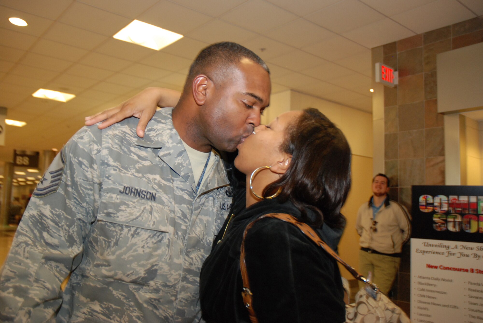 Master Sgt. Harold Johnson, 94th Security Forces Squadron, kisses his wife, Chekesha Johnson, at the Atlanta Hartsfield-Jackson Airport Jan. 5. Sergeant Johnson and five other Security Forces Airmen returned home from a six-month deployment to Southwest Asia in support of Operation Iraqi Freedom. The reserve Airmen defended their base through gate checks and random anti-terrorism measures. (U.S. Air Force photo/Master Sgt. Stan Coleman)