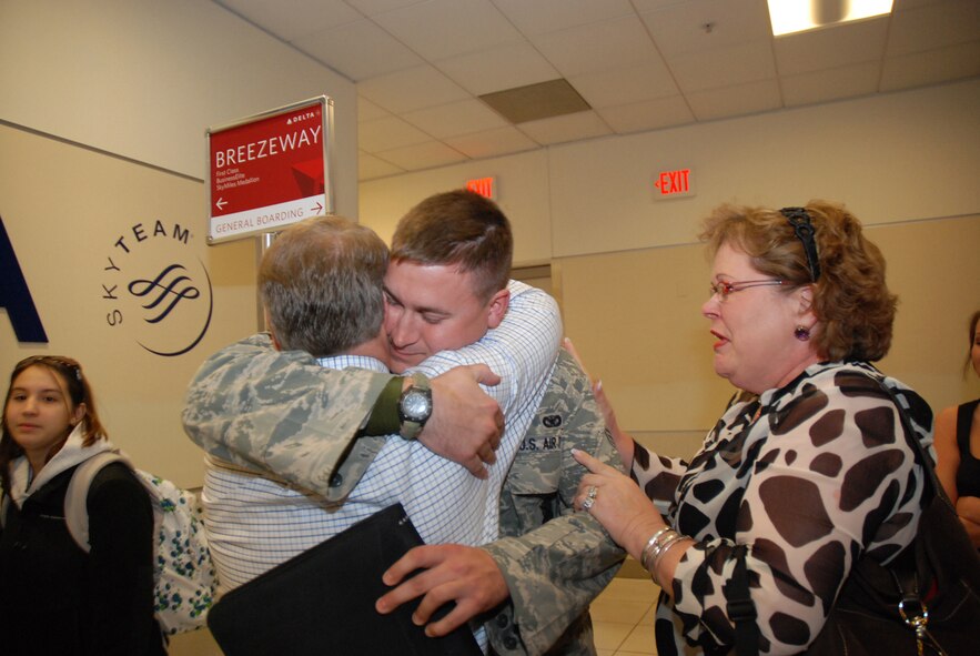 Senior Airman Russell Kuhlman Jr. hugs his father, Russell Kuhlman Sr. as his mother, Ruthie Kuhlman, watches at the Atlanta Hartsfield-Jackson Airport Jan. 5. Senior Airman Kuhlman and five other Security Forces Airmen returned home Jan. 5 from a six-month deployment to Southwest Asia in support of Operation Iraqi Freedom. (U.S. Air Force photo/Master Sgt. Stan Coleman)