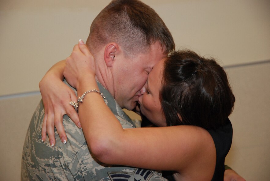 Senior Airman Russell Kuhlman, 94th Security Forces Squadron member, kisses his new fiance, McCalla Aragon, at the Atlanta Hartsfield-Jackson Airport Jan. 5. Airman Kuhlman proposed to Ms. Aragon immediately after getting off the plane.  Half a dozen Security Forces Airmen returned home Jan. 5 from a six-month deployment to Southwest Asia in support of Operation Iraqi Freedom. (U.S. Air Force photo/Master Sgt. Stan Coleman)
