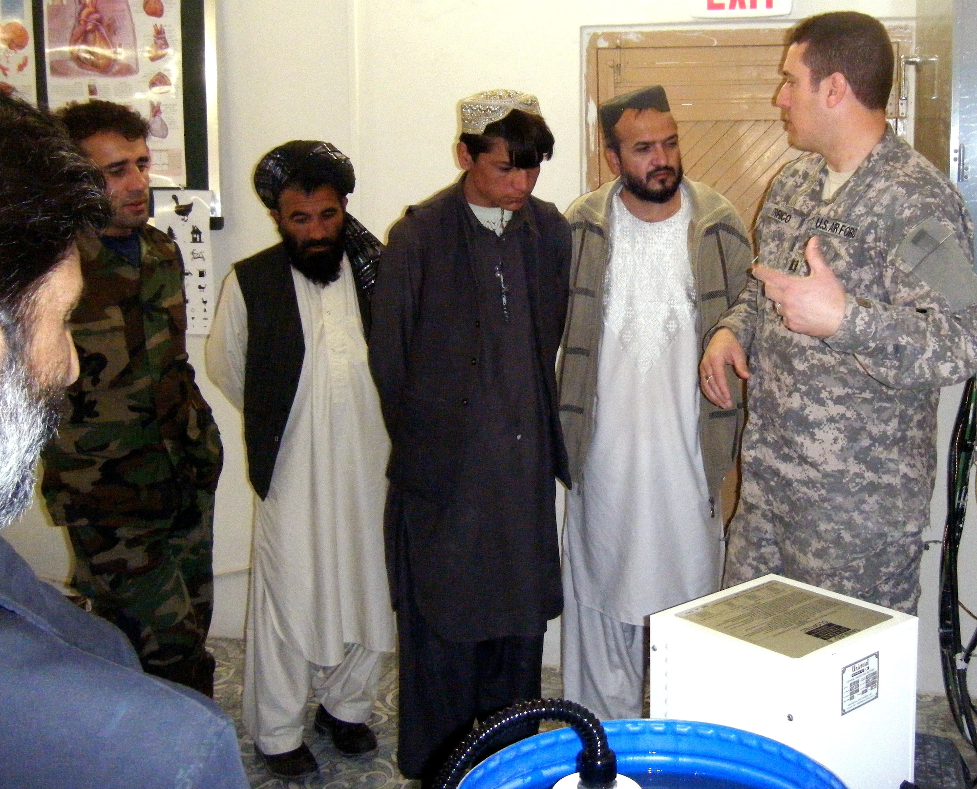Air Force Capt. (Dr.) Bill Errico of the provincial reconstruction team in Afghanistan's Zabul province, shows Iraqi doctors how to use a water purification machine. The PRT medical team donated water purification systems to hospitals throughout the province. (U.S. Air Force photo/Airman 1st Class Mary Costello) 
