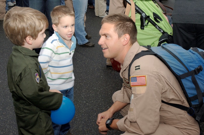 Capt. Ben Tarkowski talks with his sons Henry (left) and Paul (center) after returning from a deployment on the flightline at Charleston AFB, S.C. Jan. 3. More than a 130 Airmen from the 15th Airlift Squadron returned from their 120-day deployment in Southwest Asia. Capt. Tarkowski is a pilot assigned to the 15th Airlift Squadron. (U.S. Air Force photo/Staff Sgt. Marie Cassetty)