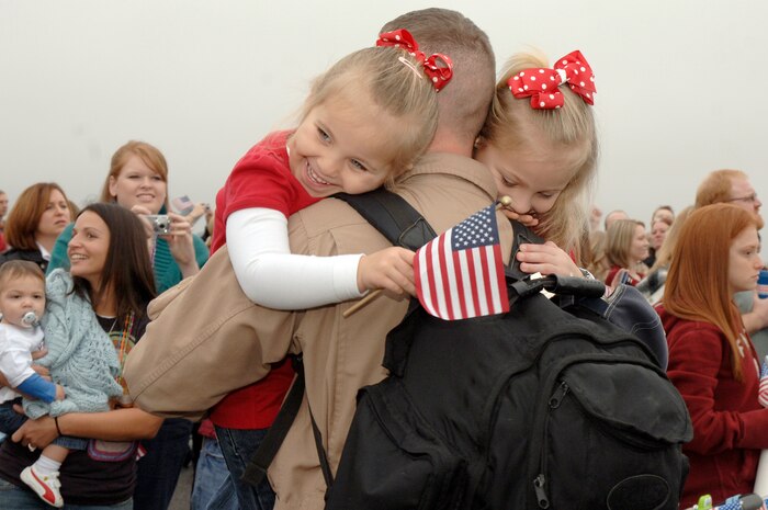 Annsley (left) and Ashlyn (right) Oelrich hug their dad Capt. Aaron Oelrich after he returned from a deployment on the flightline at Charleston AFB, S.C. Jan. 3. More than a 130 Airmen from the 15th Airlift Squadron returned from their 120-day deployment in Southwest Asia. Capt. Oelrich is a pilot assigned to the 15th Airlift Squadron. (U.S. Air Force photo/Staff Sgt. Marie Cassetty)