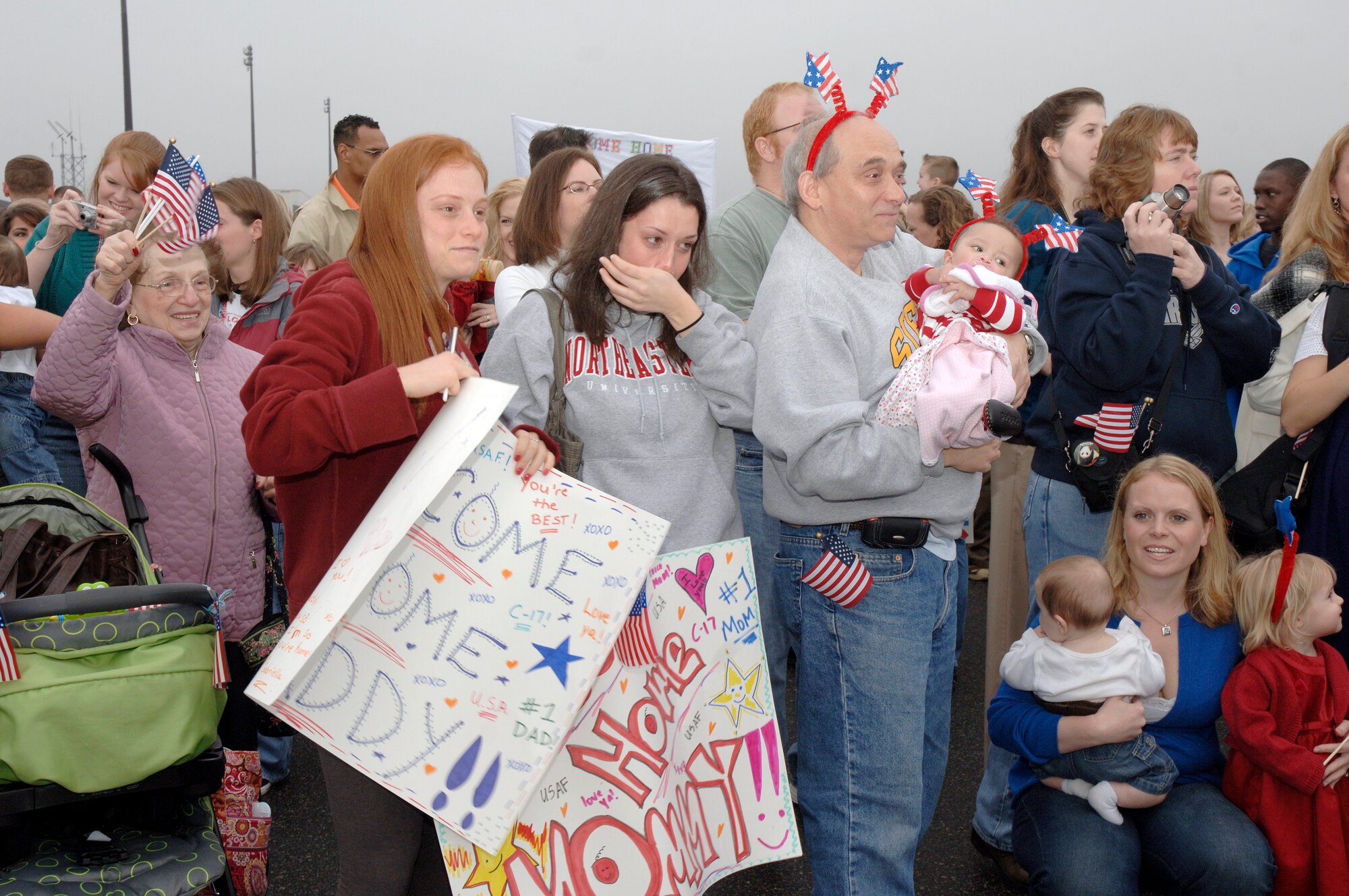 Family members cheer as they wait for the return of their loved ones from a deployment on the flightline at Charleston AFB, S.C. Jan. 3. More than a 130 Airmen from the 15th Airlift Squadron returned from their 120-day deployment in Southwest Asia. (U.S. Air Force photo/Staff Sgt. Marie Cassetty)