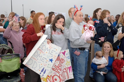 Family members cheer as they wait for the return of their loved ones from a deployment on the flightline at Charleston AFB, S.C. Jan. 3. More than a 130 Airmen from the 15th Airlift Squadron returned from their 120-day deployment in Southwest Asia. (U.S. Air Force photo/Staff Sgt. Marie Cassetty)