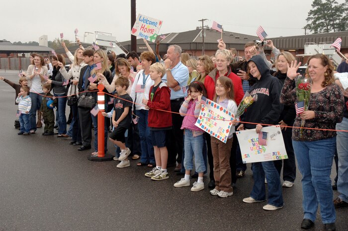 Family members cheer as they wait for the return of their loved ones from a deployment on the flightline at Charleston AFB, S.C. Jan. 3. More than a 130 Airmen from the 15th Airlift Squadron returned from their 120-day deployment in Southwest Asia. (U.S. Air Force photo/Staff Sgt. Marie Cassetty)