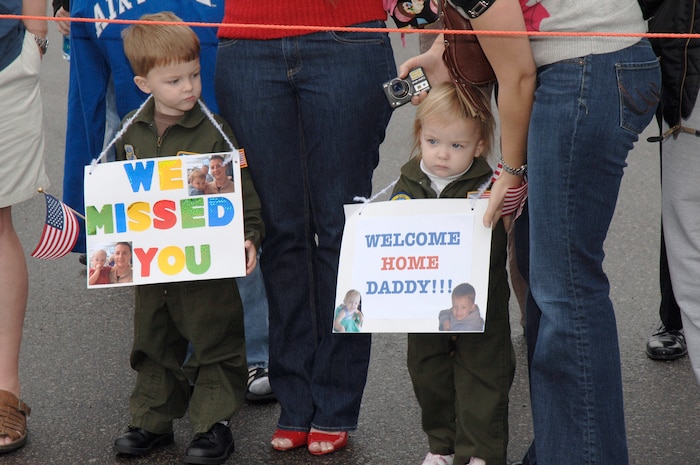 Sean and Abigail Foss hold a sign as they wait for the return of their dad Capt. Matthew Foss on the flightline at Charleston AFB, S.C. Jan. 3. More than a 130 Airmen from the 15th Airlift Squadron returned from their 120-day deployment in Southwest Asia. Capt. Foss is a pilot assigned to the 15th Airlift Squadron. (U.S. Air Force photo/Staff Sgt. Marie Cassetty)
