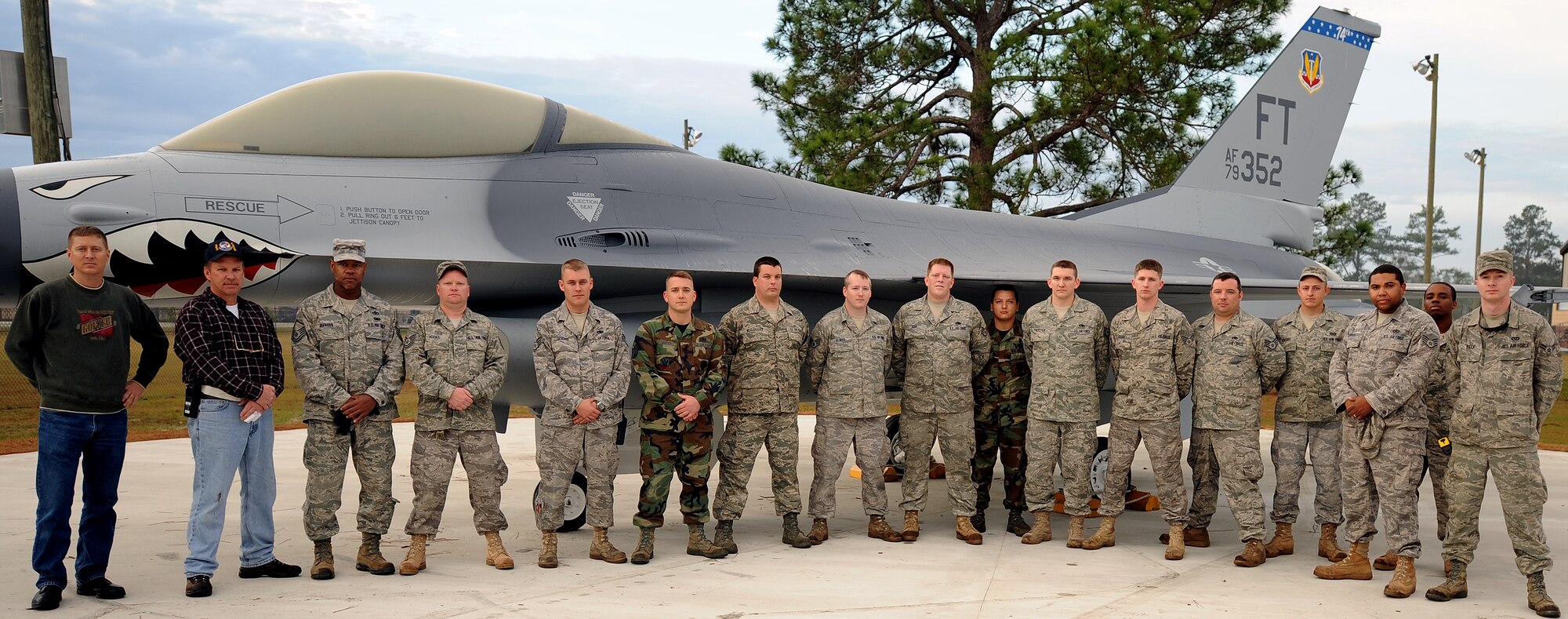 MOODY AIR FORCE BASE, Ga. -- Airmen from the 23rd Equipment Maintenance Squadron and 23rd Civil Engineer Squadron take a group photo with an F-16C Fighting Falcon static display in front of the Michael Maltz First-Term Airman and Professional Enhancement Center here Jan. 4. The two squadrons worked together to relocate the F-16C to the professional development center.  The aircraft was flown by the 74th Fighter Squadron while the 23rd Fighter Group was at Pope Air Force Base, N.C. (U.S. Air Force photo by Airman Joshua Green)