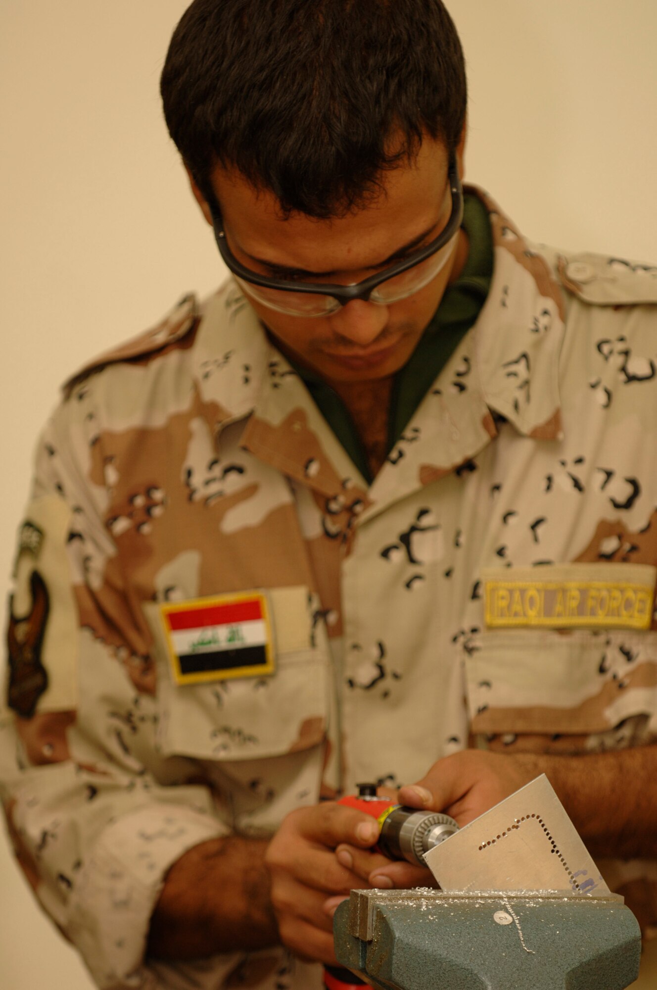 TAJI, Iraq -- Iraqi air force warrant officer Hussen Mohammad practices chain drilling a sheet of metal during the fabrication section of the aircraft structural maintenance course at Al-Taji Air Base. (U.S. Air Force photo/Staff Sgt. Paul Villanueva II)