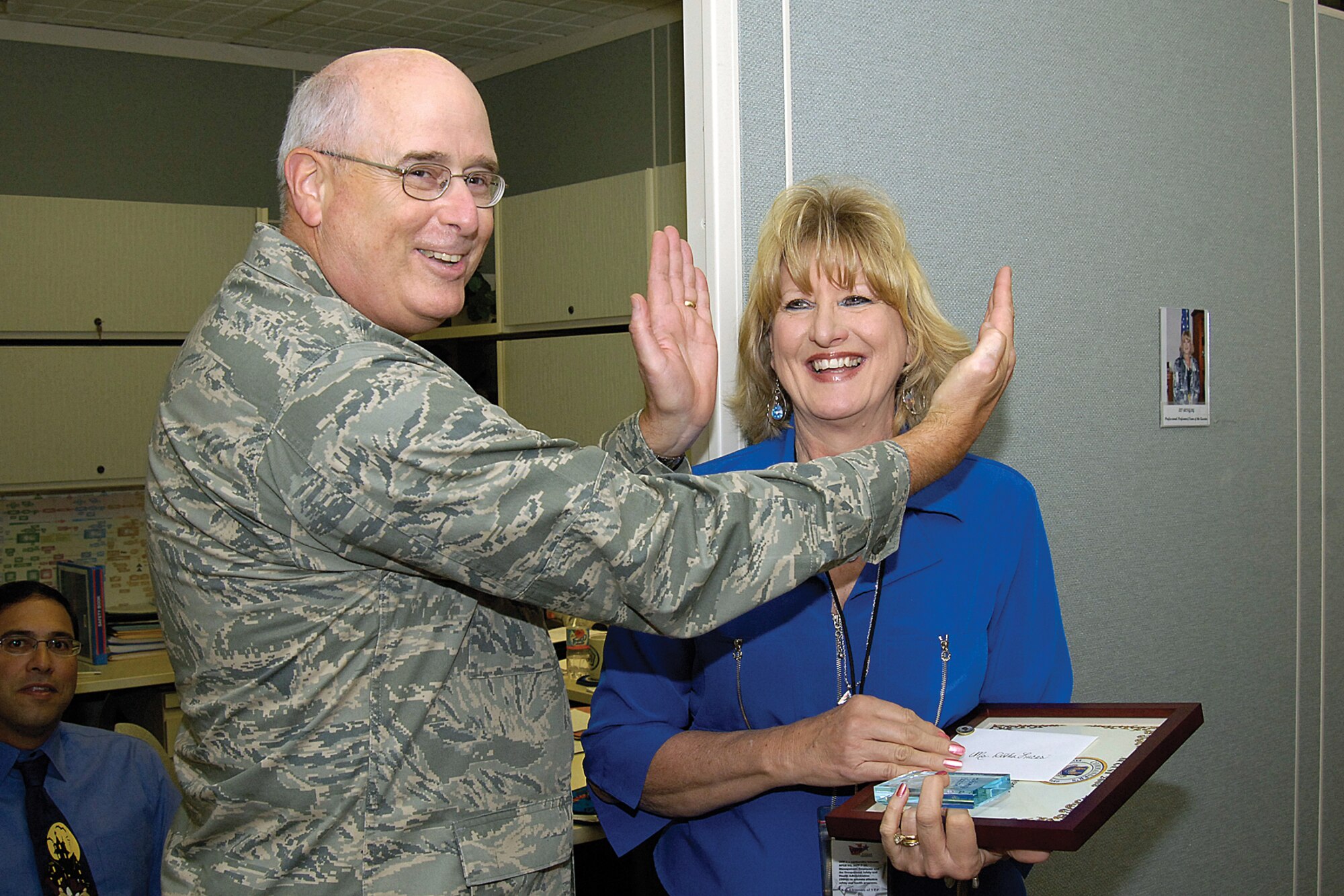 After surprising Retha Lucas with a Commander’s Excellence in Action award, Maj. Gen. Loren Reno frames her face and tells the gathered crowd that Ms. Lucas is what excellence in action looks like.  The commander frequently praised Tinker’s workforce in formal ceremonies and informally when walking through the work centers.(Air Force photo/Margo Wright)