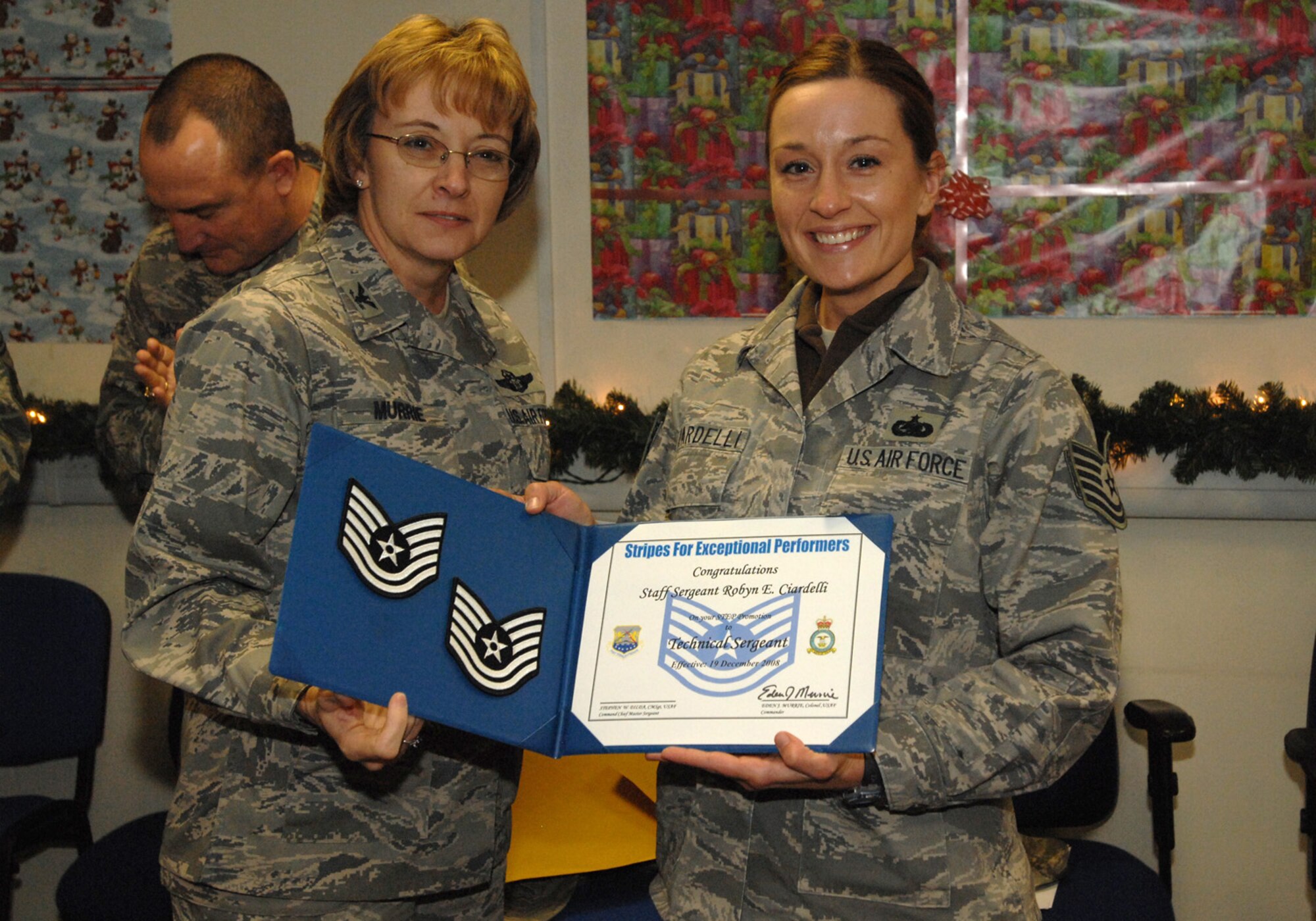 Col. Eden J. Murrie, 100th Air Refueling Wing commander, promotes Staff Sgt. Robyn Ciardelli, 100th Logistics Readiness Squadron Aircraft Parts Store supervisor, to the rank of technical sergeant under the Stripes for Exceptional Performers program Dec. 19. The STEP program is a highly visible promotion recognition program used by commanders at all levels to recognize the outstanding contributions and accomplishments of senior airmen, staff sergeants and technical sergeants. (U.S. Air Force photo by Senior Airman Teresa Hawkins)