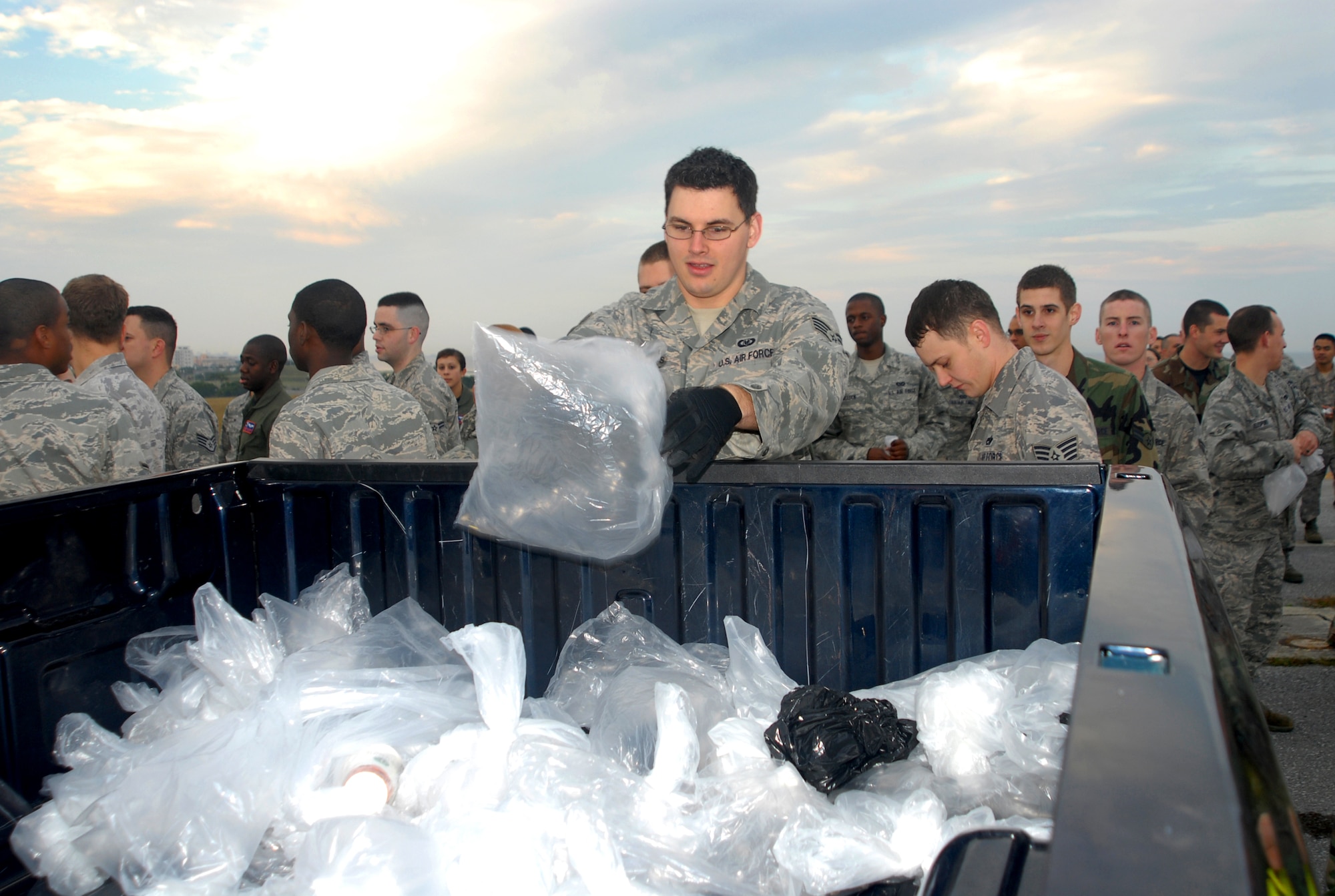 Staff Sgt. Thomas Holmes, 718th Civil Engineer Squadron, tosses his bag of foreign object debris (FOD) into a collection truck Jan. 5 during the annual Team Kadena FOD Walk.  More than 400 Airmen volunteered their time for the event. (U.S. Air Force photo/Staff Sgt. Nestor Cruz)