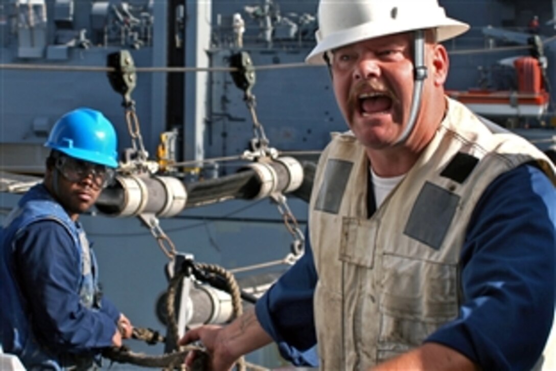 U.S. Navy Chief Warrant Officer Shawn Stacey relays commands to line handlers during an underway replenishment with the dry cargo and ammunition ship USNS Lewis & Clark aboard the amphibious transport dock ship USS San Antonio in the Persian Gulf, Dec. 27, 2008.