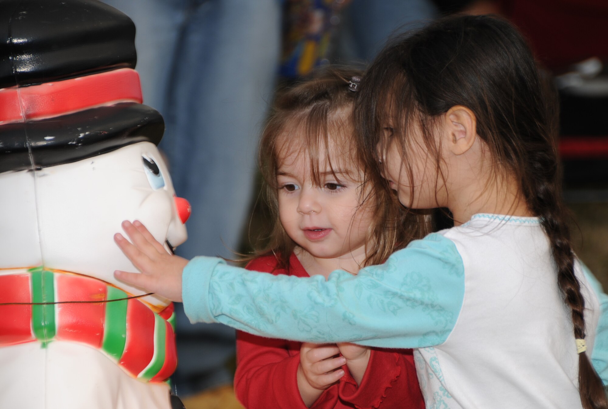 Isabella Parrotta, left, and Olivia Salinas admire an illuminated snowman at Christmas in the Park, Dec. 17.  Isabella, 2, is the daughter of Staff Sgt. Eugene Parrotta, 81st Medical Support Squadron.  Olivia, 3, is the daughter of Army Sgt. Jason and Darla Salinas.  Sergeant Salinas is assigned to the 81st MDSS clinical research laboratory.  The annual event featured a toy giveaway made possible by a grant from the USO.   Festivities also included a  tree lighting, live Nativity scene, train and carriage rides, refreshments, caroling and Santa’s arrival by fire engine.  (U.S. Air Force photo by Kemberly Groue)