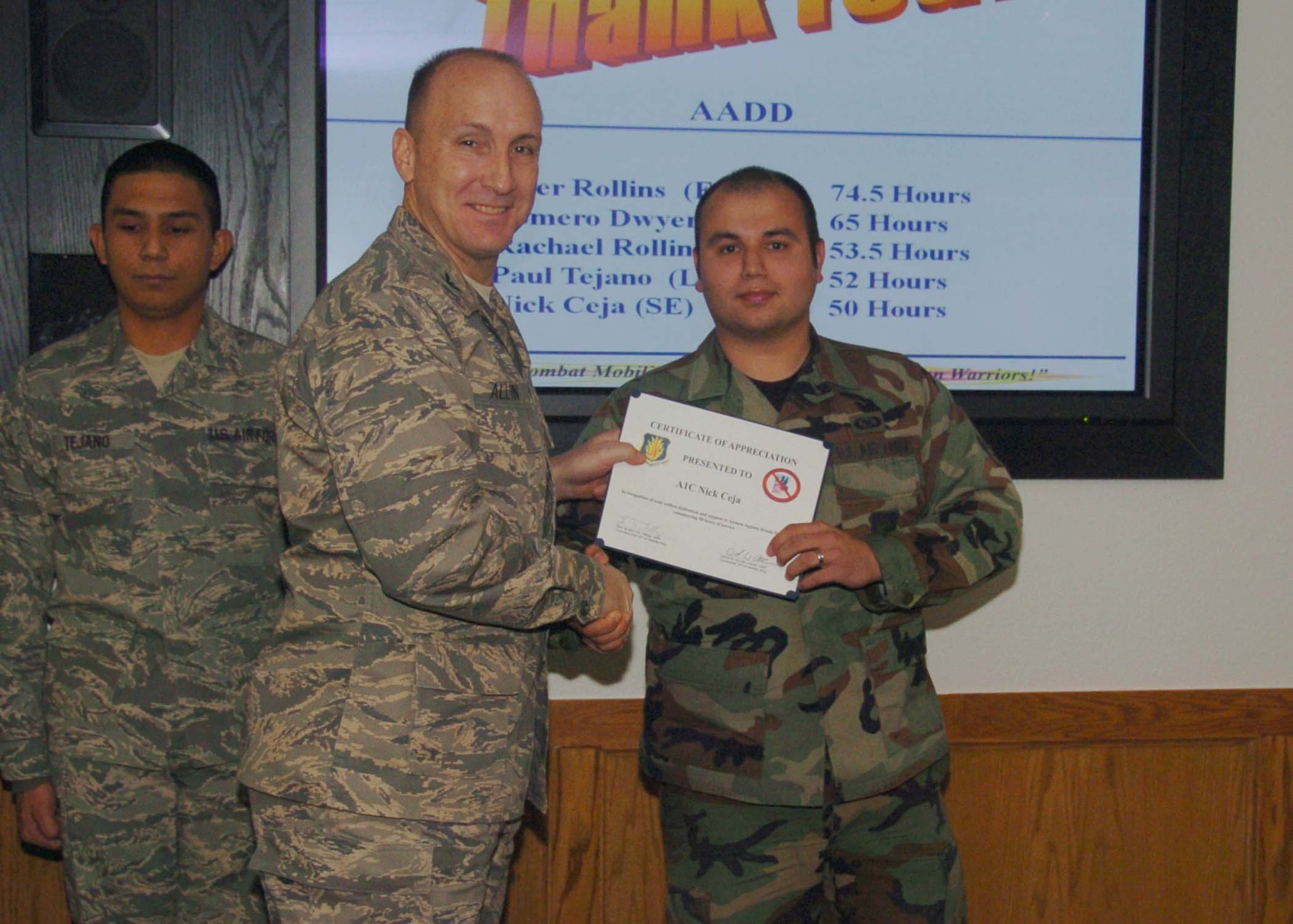 ALTUS AIR FORCE BASE, Okla. -- Airman First Class Nick Ceja (r), 97th Air Mobility Wing, receives a wing coin and certificate from Col. David Allvin, 97th Air Mobility Wing commander Jan. 6. Airman Ceja was recognized for volunteering 50 hours to the Airmen Against Drunk Driving program. (U.S. Air Force photo/ Airman 1st Class Tiffany M. Deuel)