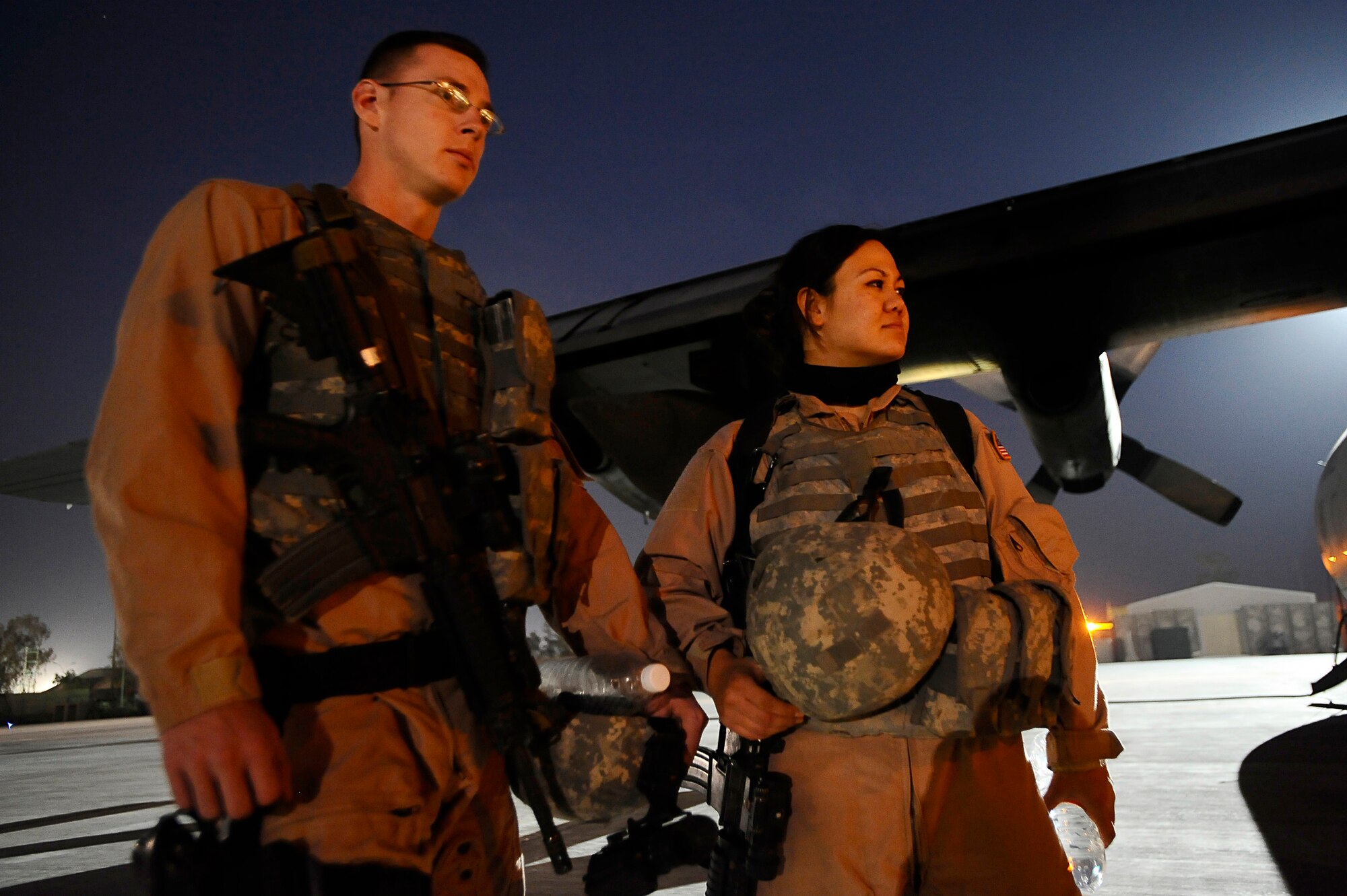 Senior Airmen Matthew Rinehart and Rosie Munoz stand outside of a C-130 Hercules Dec. 31, 2008, at Joint Base Balad, Iraq. The Airmen serve as the aircraft's Fly Away Security Team, which provides ground security for the aircraft as it loads and unloads cargo at unsecured airfields. Airmen Rinehart and Munoz are deployed to the 332nd Expeditionary Security Forces Team from Andrews Air Force Base, Md. Airman Rinehart's hometown is York, Pa. Airman Munoz's hometown is El Paso, Texas. (U.S. Air Force photo/Airman 1st Class Jason Epley) 
