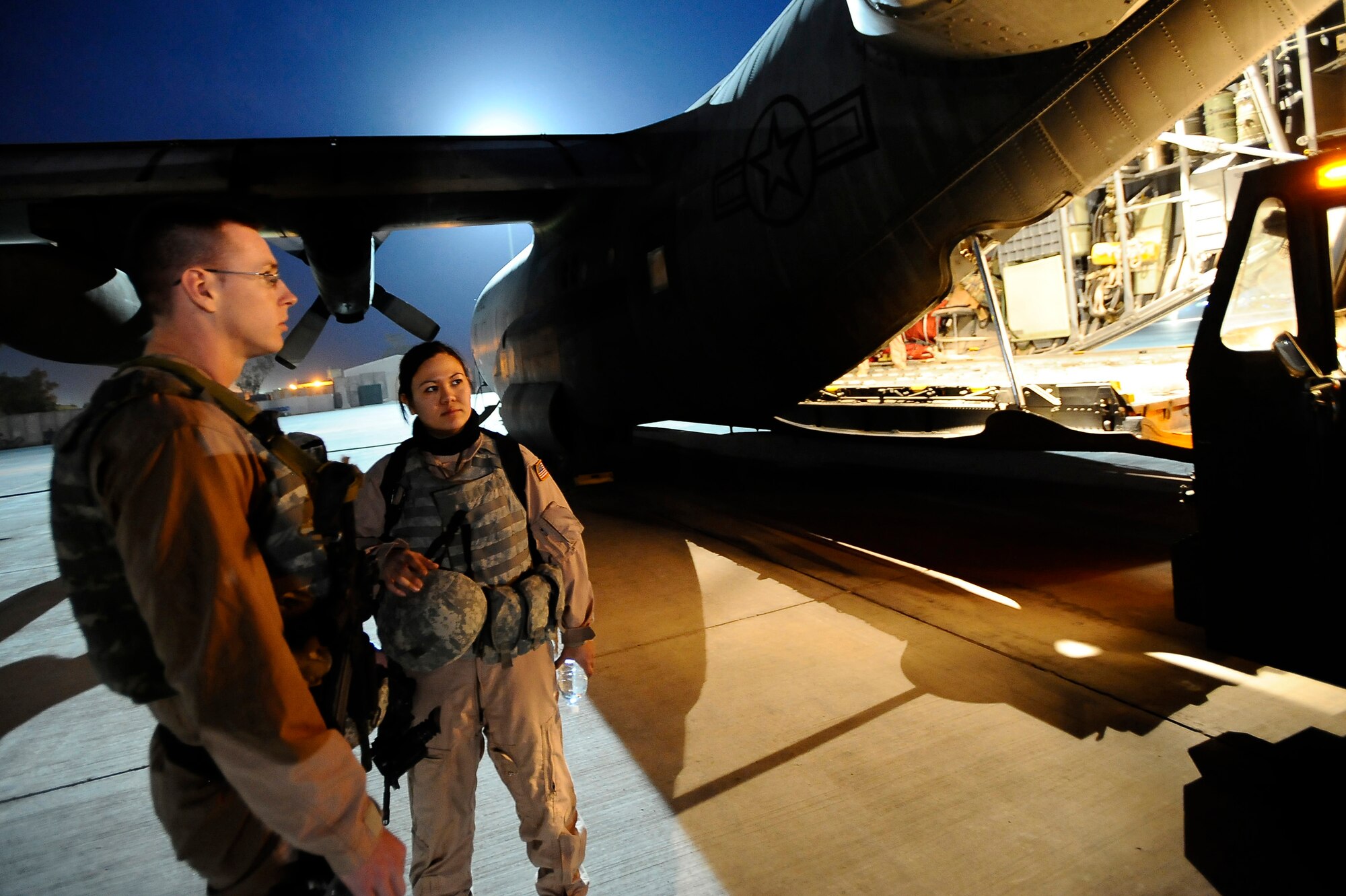 Senior Airmen Matthew Rinehart and Rosie Munoz stand outside of a C-130 Hercules Dec. 31, 2008, at Joint Base Balad, Iraq. The Airmen serve as the aircraft's Fly Away Security Team, which provides ground security for the aircraft as it loads and unloads cargo at unsecured airfields. Airmen Rinehart and Munoz are deployed to the 332nd Expeditionary Security Forces Team from Andrews Air Force Base, Md. Airman Rinehart's hometown is York, Pa. Airman Munoz's hometown is El Paso, Texas. (U.S. Air Force photo/Airman 1st Class Jason Epley) 
