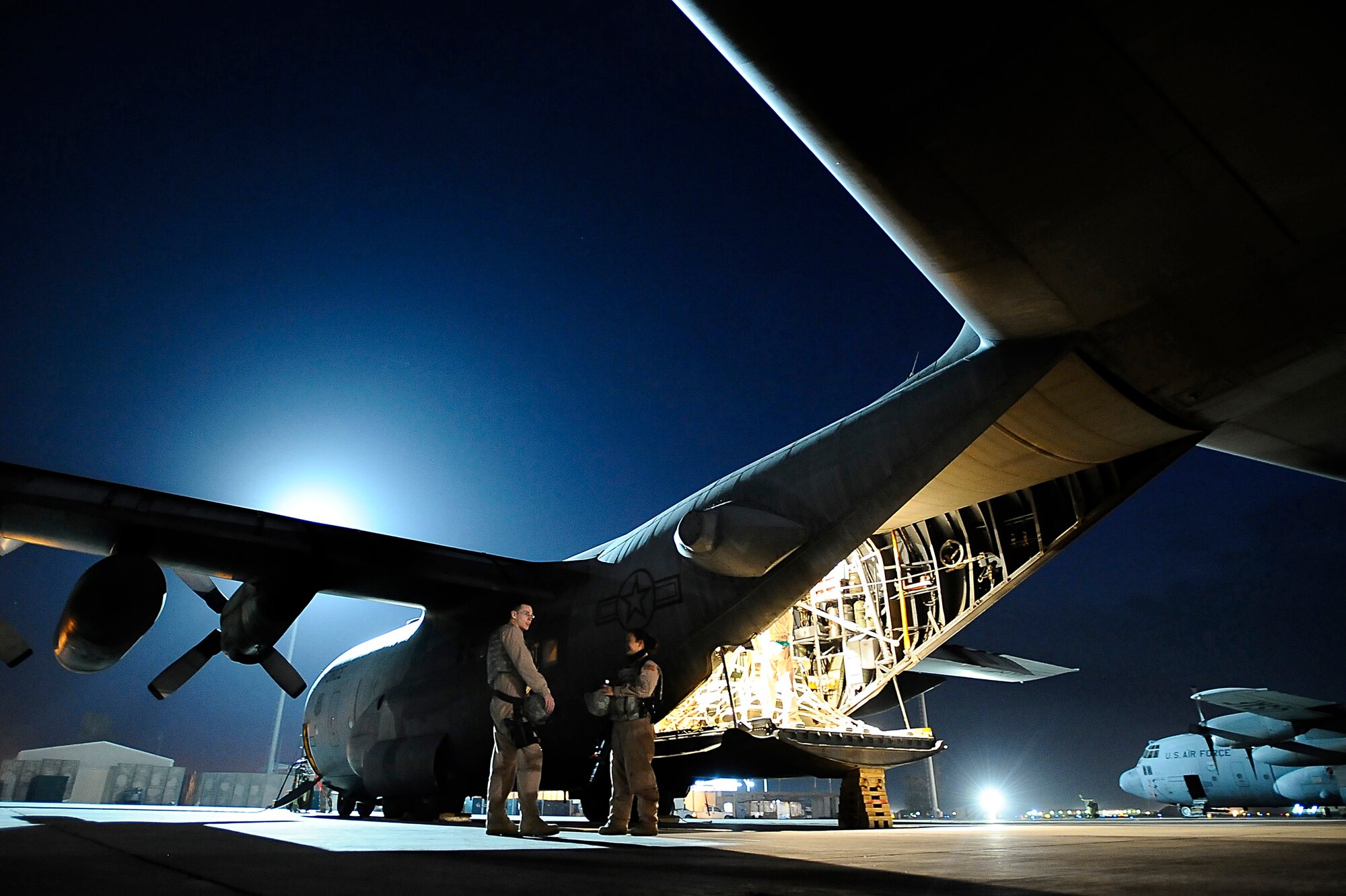 Senior Airmen Matthew Rinehart and Rosie Munoz stand outside of a C-130 Hercules Dec. 31, 2008, at Joint Base Balad, Iraq. The Airmen serve as the aircraft's Fly Away Security Team and provide ground security for the aircraft as it loads and unloads cargo at unsecured airfields. Airmen Rinehart and Munoz are deployed to the 332nd Expeditionary Security Forces Squadron from Andrews Air Force Base, Md. Airman Rinehart's hometown is York, Pa. Airman Munoz is from El Paso, Texas. (U.S. Air Force photo/Airman 1st Class Jason Epley) 
