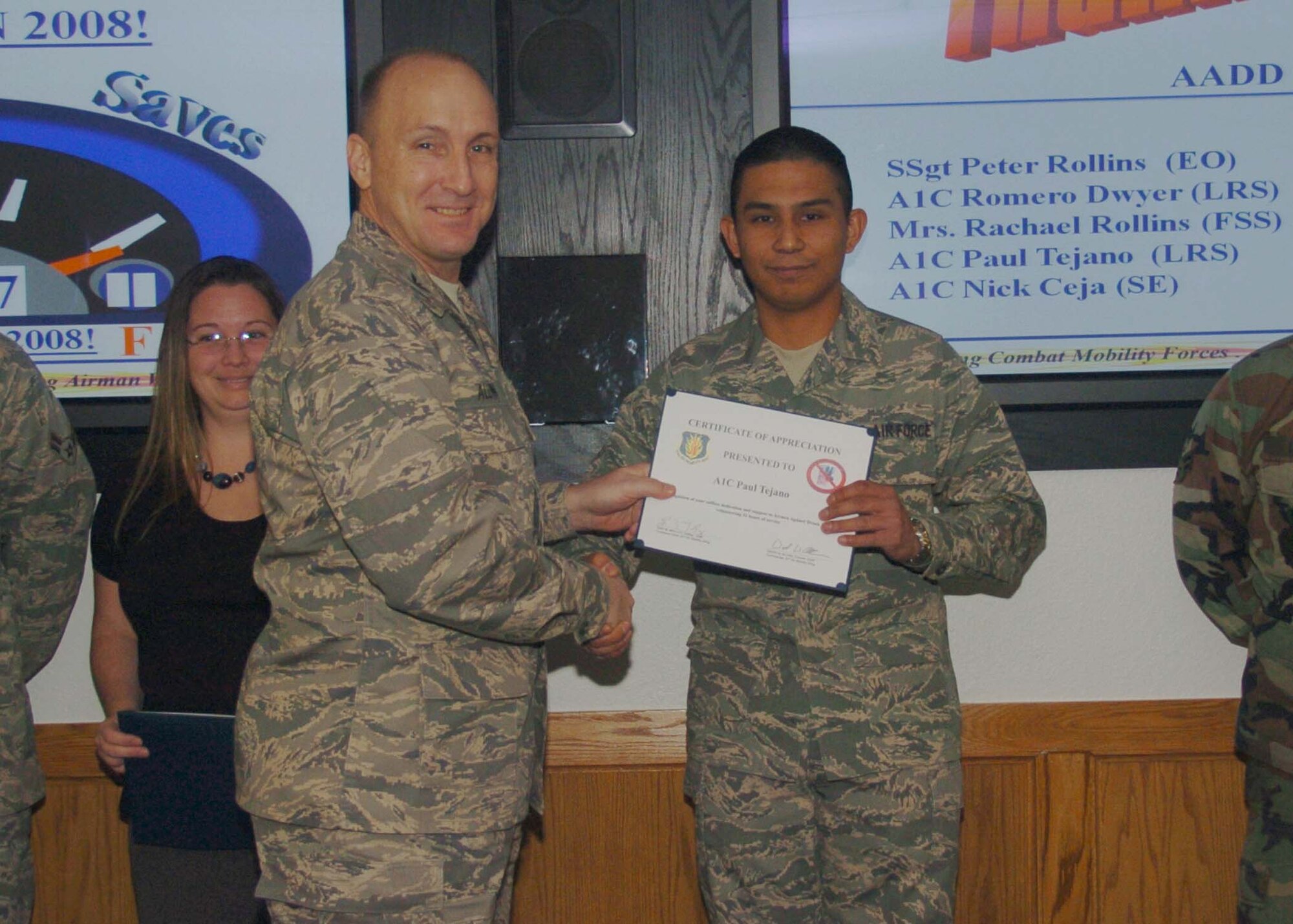 ALTUS AIR FORCE BASE, Okla. -- Airman First Class Paul Tejano (r), 97th Logistics Readiness Squadron, receives a wing coin and certificate from Col. David Allvin, 97th Air Mobility Wing commander Jan. 6. Airman Tejano was recognized for volunteering 50 hours to the Airmen Against Drunk Driving program. (U.S. Air Force photo/ Airman 1st Class Tiffany M. Deuel)