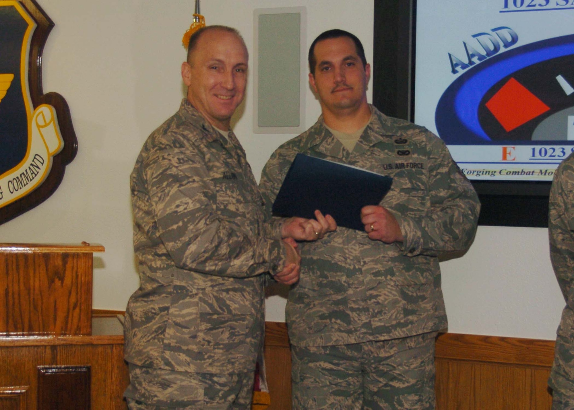 ALTUS AIR FORCE BASE, Okla. -- Staff Sgt. Pete Rollins (r), 97th Air Mobility Wing, receives a wing coin and certificate of achievement from Col. David Allvin, 97th Air Mobility Wing commander. Colonel Allvin recognized the top volunteers for the Airmen Against Drunk Driving program Jan. 6. Sergeant Rollins coordinates and recruits volunteeers for AADD, which provides free rides to base personnel to prevent drunk driving. (U.S. Air Force photo/ Airman 1st Class Tiffany M. Deuel)