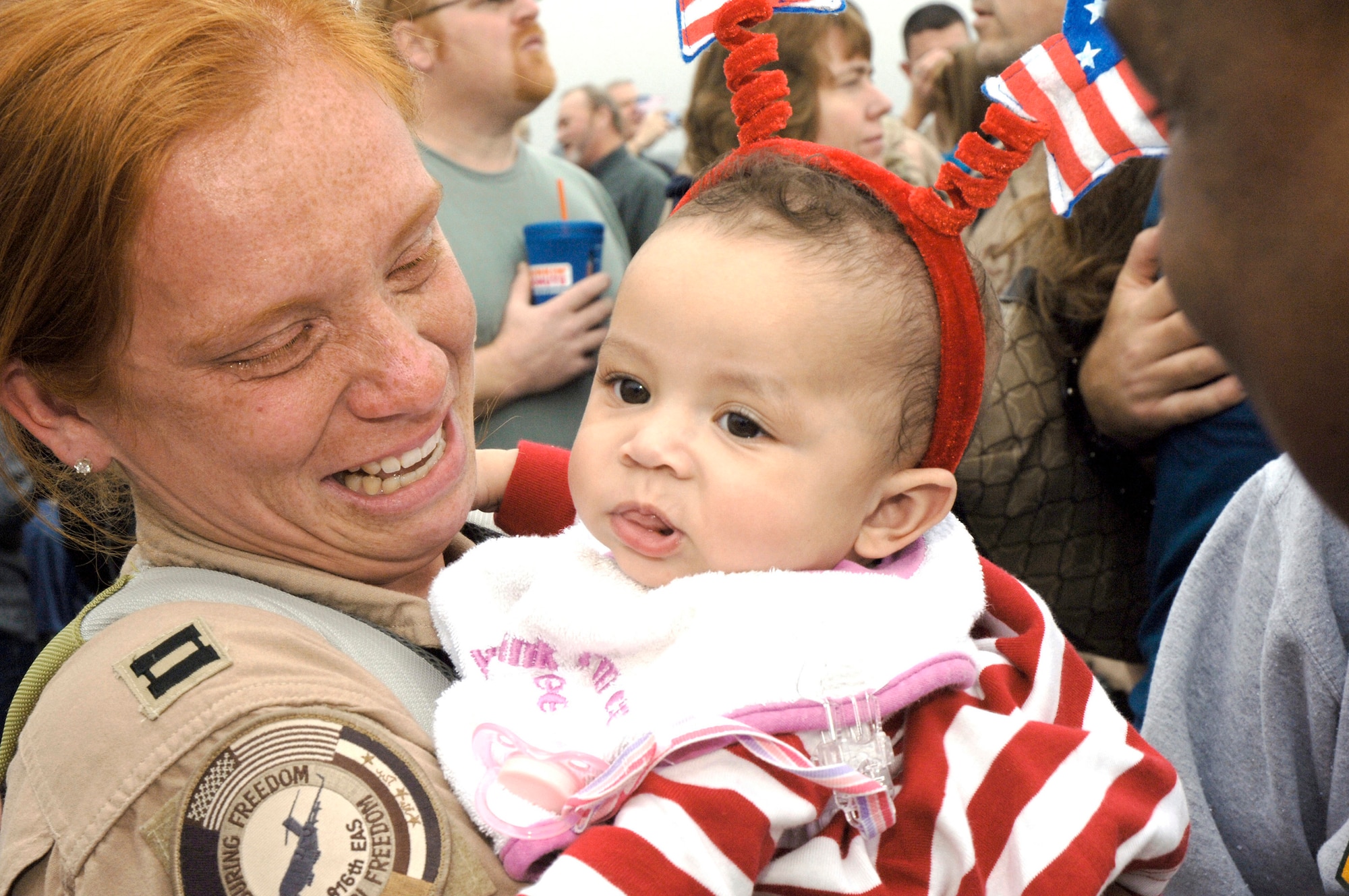 Capt. Jennifer Moore cries as she holds her daughter, Gabriella, after returning from a deployment Jan. 3 at Charleston Air Force Base, S.C. More than 130 Airmen from the 15th Airlift Squadron returned from their 120-day deployment in Southwest Asia. Captain Moore is assigned to the 15th Airlift Squadron. (U.S. Air Force photo/Staff Sgt. Marie Cassetty)