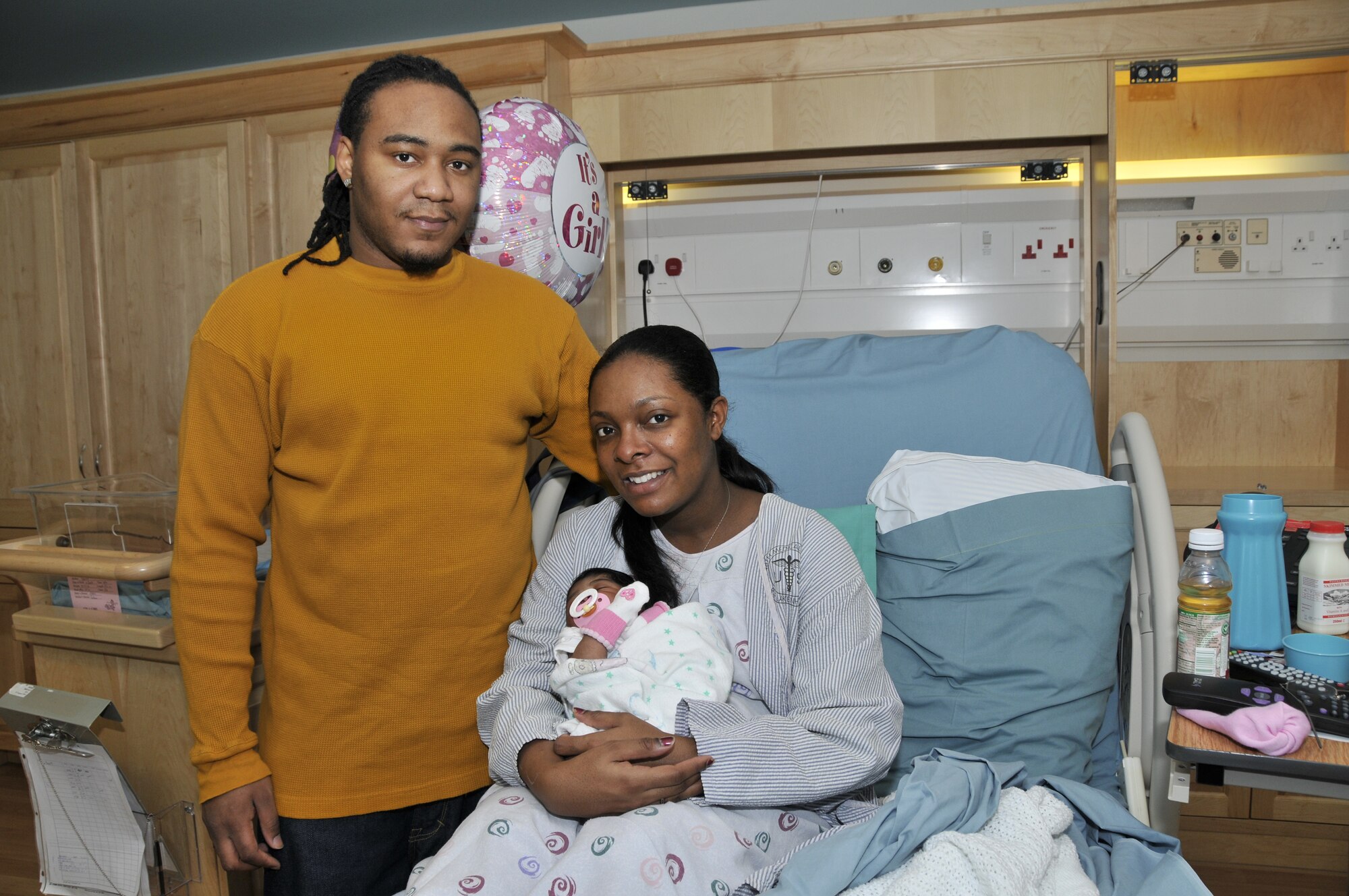 Airman 1st Class Tabitha Reynolds, 100th Communication squadron, and her husband, Josh, sit with Malia Kamari Reynolds, the first baby born in the new year, Jan. 2 at RAF Lakenheath, England. Malia was born Jan. 1 at 10:56 p.m. weighing 5 pounds, 9 ounces. (U.S. Air Force photo by Airman 1st Class Perry Aston) 
