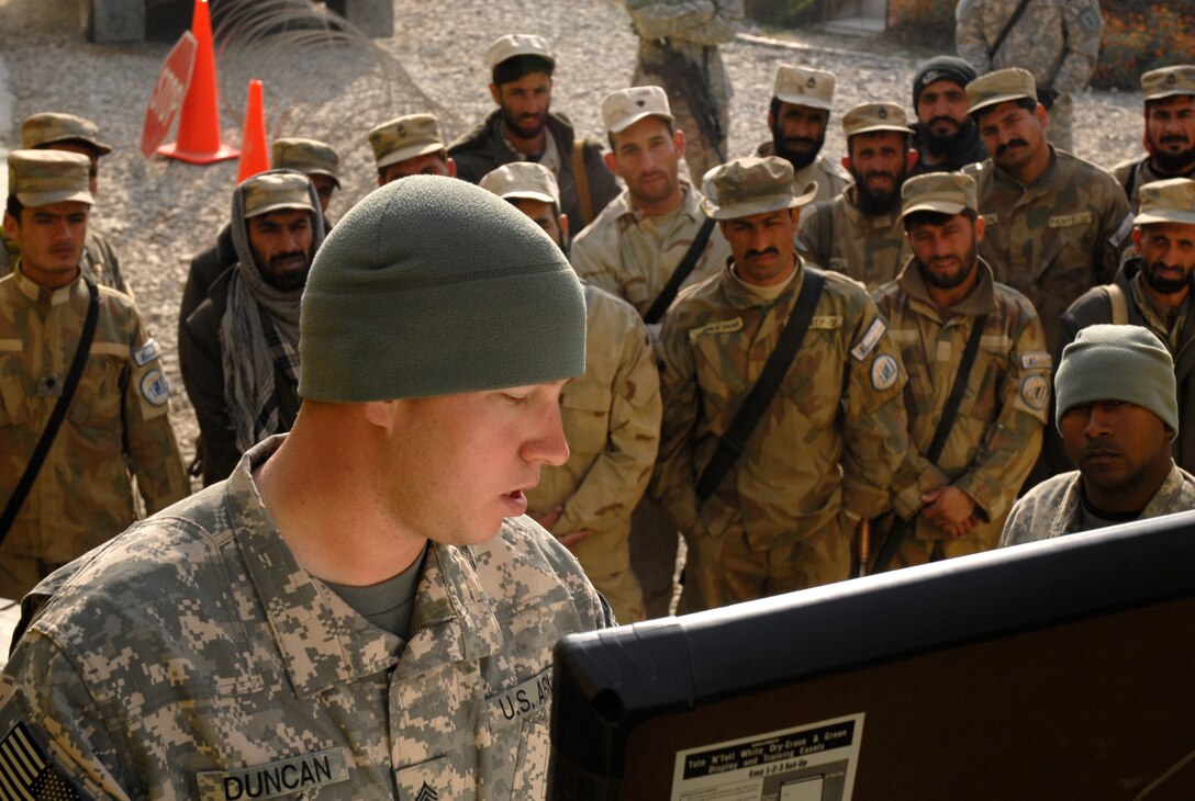 Army Sgt. Aaron Duncan, Company A, 201st Brigade Support Battalion, explains a traffic control point to Afghan security guards. U.S. Army photo by Sgt. Charles Brice