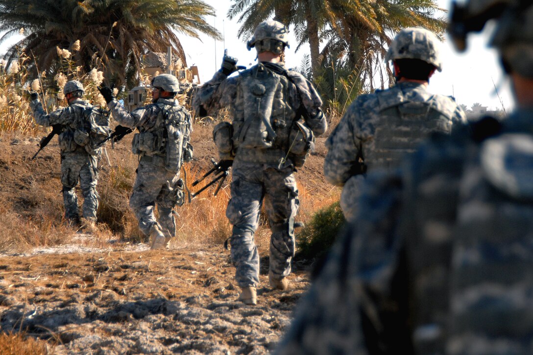 U.S. Army soldiers signal each other during a munitions search near Forward Operating Base Kalsu, Iraq, Dec. 29, 2008. The soldiers are assigned to 1st Battalion, 2nd Infantry Regiment, 172nd Infantry Brigade.