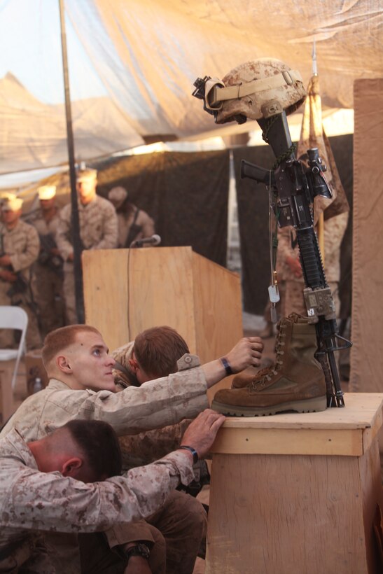 Cpl. Zachary Wallick, a squad leader with 3rd Platoon, Echo Company, 2nd Battalion, 6th Marine Regiment, pays his respects to 1st Lt. James Zimmerman, his former platoon commander, during a memorial service at Patrol Base Shanfield, Helmand province, Afghanistan, Nov. 11. Zimmerman was from Aroostock, Maine.