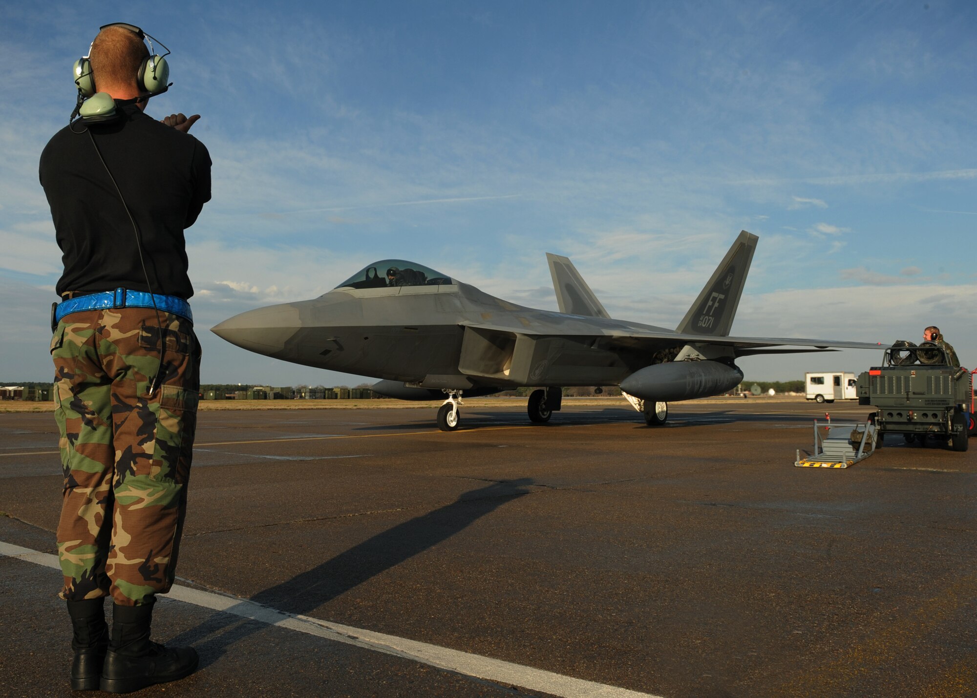 LANGLEY AIR FORCE BASE, Va. --  Senior Airman Daniel Glabinski, 27th Aircraft Maintenance Unit F-22A Raptor crew chief, prepares to signal a pilot from the 192nd Fighter Wing, Virginia Air National Guard, just before take-off on a deployment to Kadena Air Base, Japan, Jan. 7.  More than 200 personnel and 12 F-22A Raptors from the 27th Fighter Squadron departed for Japan for their Air Expeditionary Force deployment, which demonstrates the continued U.S. commitment to fulfill it security responsibilities through the Western Pacific. (U.S. Air Force photo/Senior Airman Vernon Young)