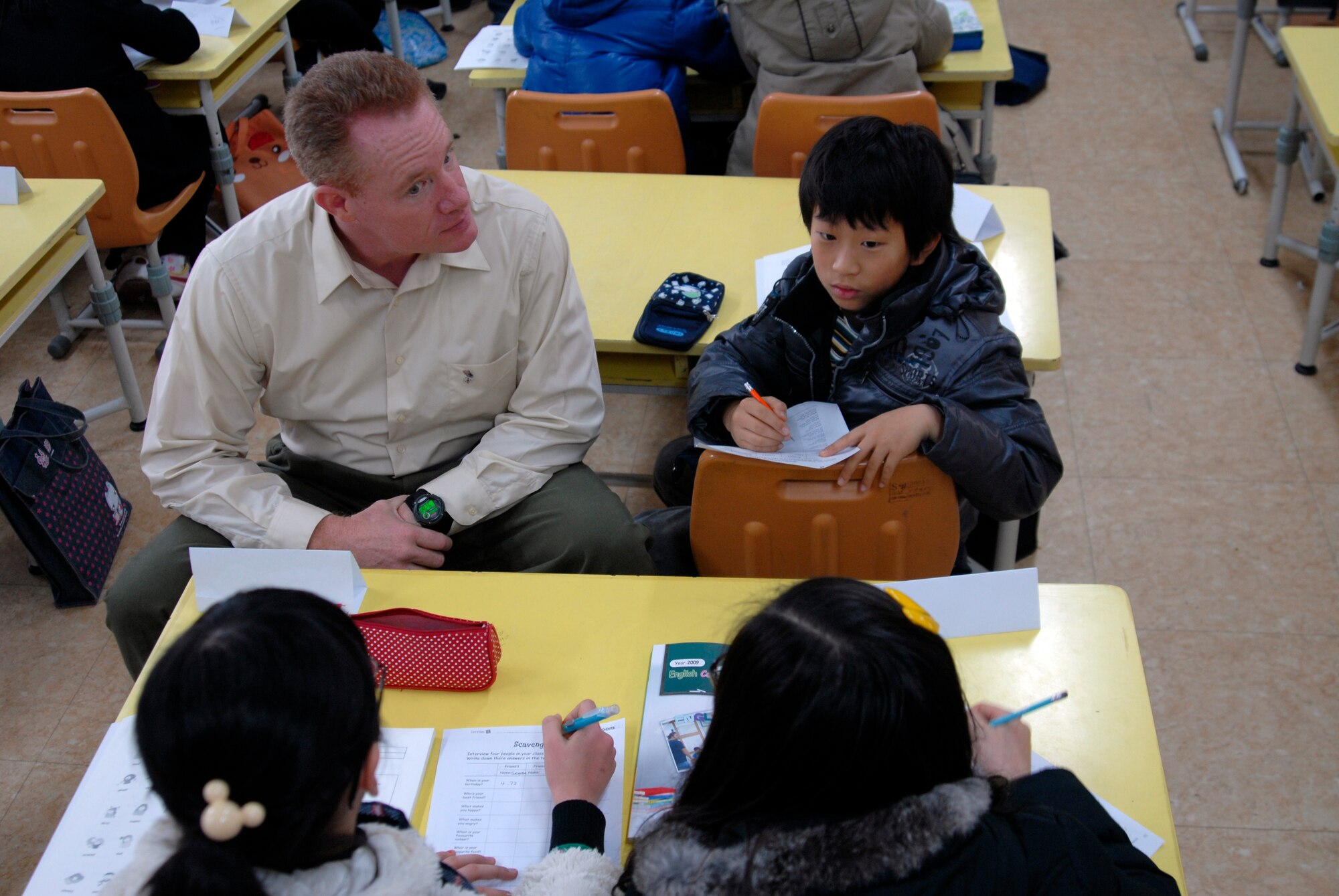 Technical Sgt. John Cronin, 8th Fighter Wing Public Affairs, talks with Korean children at a local school while teaching English. Kunsan Airmen regularly volunteer to teach English to local children. The program is part of United States Forces Korea's Good Neighbor Program.