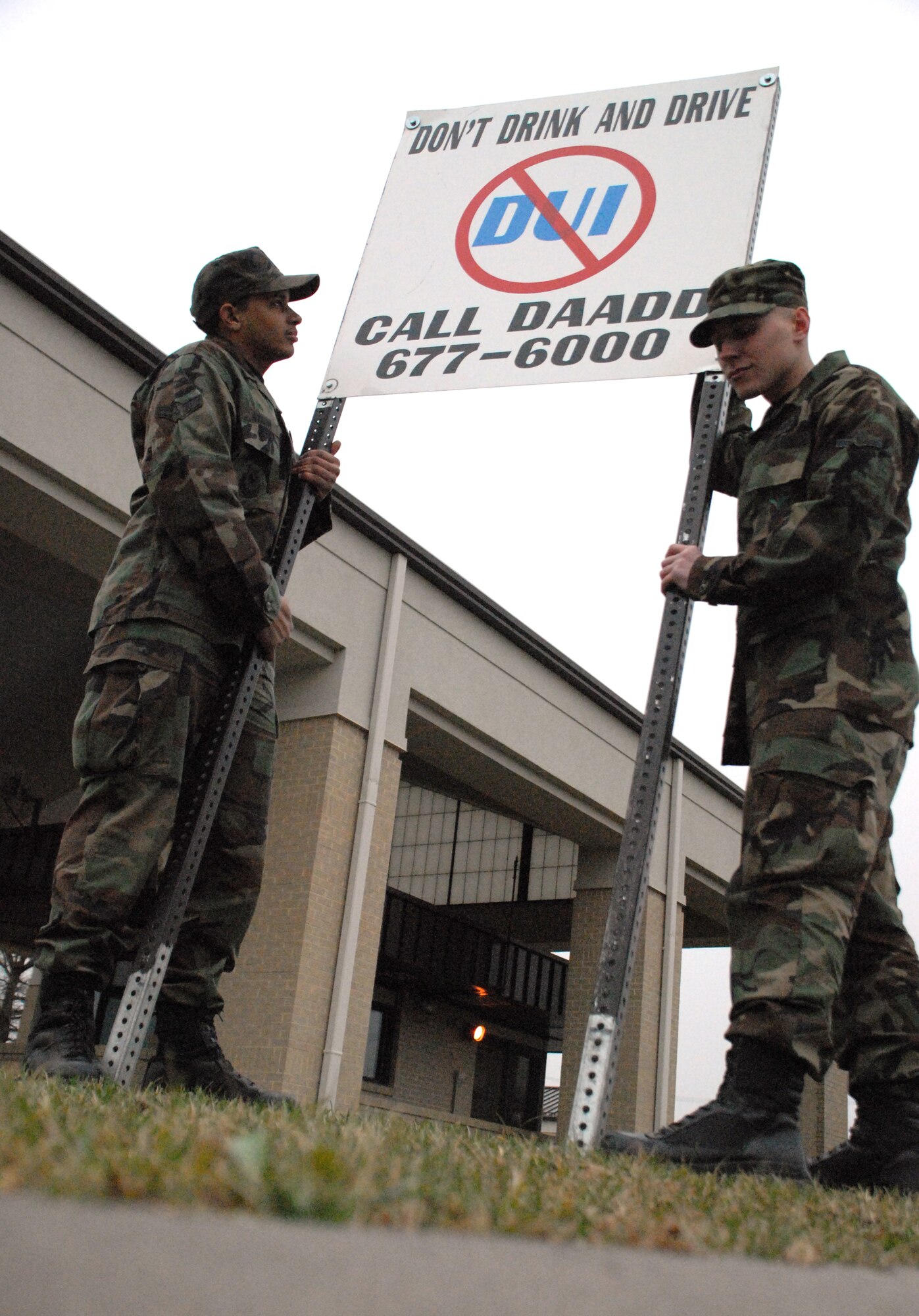 (Left to right) Airman 1st Class Christopher Kynard and Airman Zachary Mandevill, 436th Civil Engineer Squadron firefighters, install the Dover Airman Against Drunk Driving sign near the North Gate. The sign is installed every weekend as a reminder that DAADD is available to all Airmen. (U.S. Air Force photo/ Airman 1st Class Shen-Chia Chu)