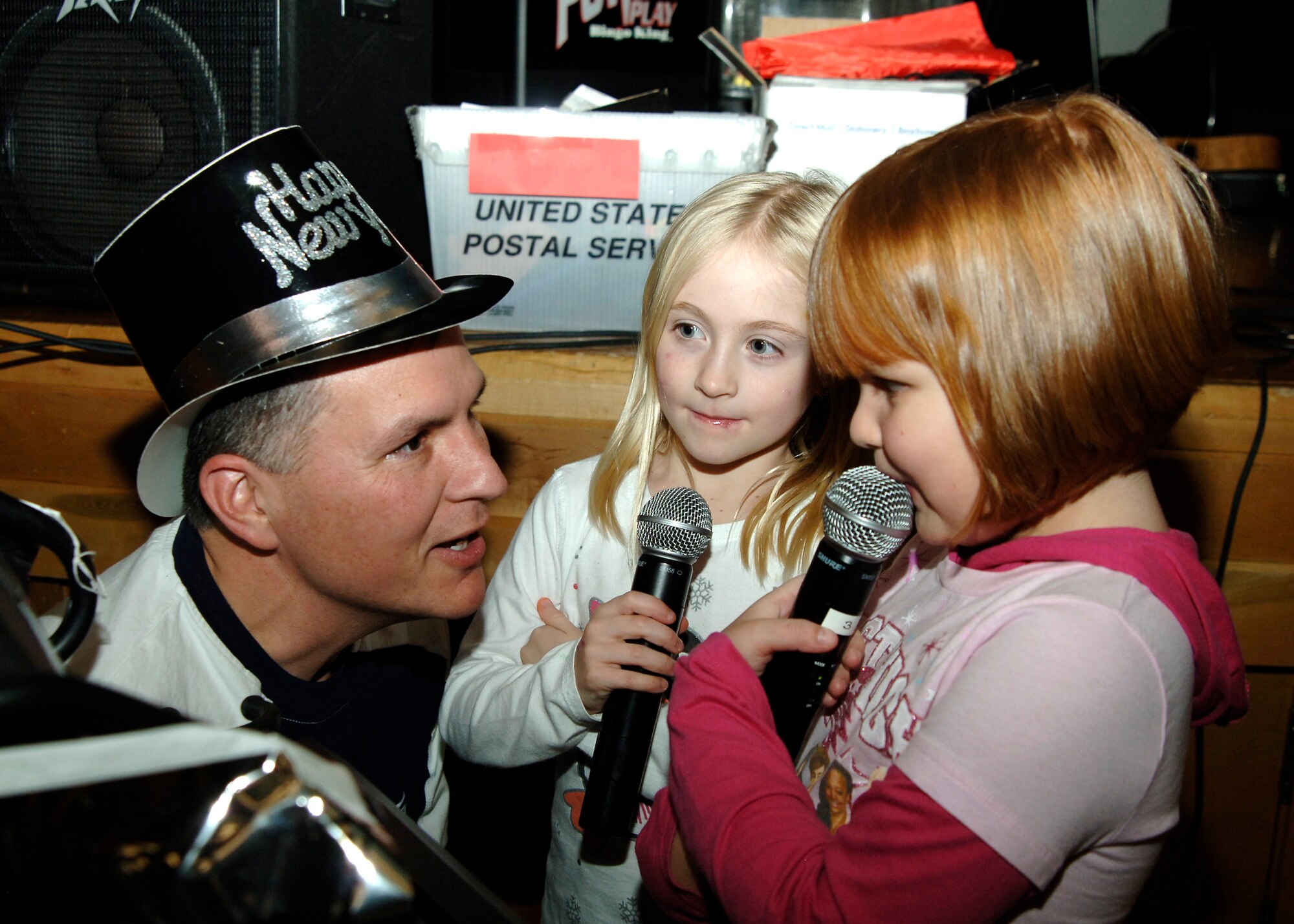 MCCONNELL AIR FORCE BASE, Kan. -- Master Sgt. David Perez, 134th Air Control Squadron, sings with Aynsley Paterson, 7, and Leanne Perez, 6, during a New Years Eve celebration held at the Robert J. Dole Community Center, Dec. 31. (Photo by Tech. Sgt. Genevieve Morris)