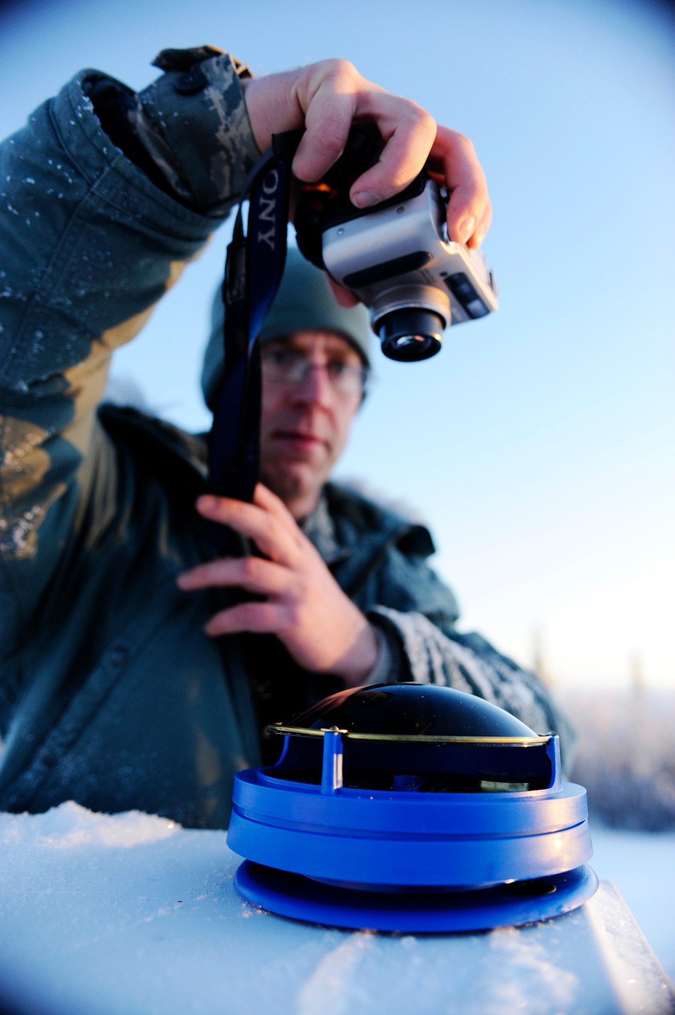 Staff Sgt. Stewart Raring captures a digital image of the solar pathfinder readings Dec. 16, 2008, at a remote operating facility in Alaska. A solar pathfinder shows the year-round, site-specific solar data to determine the best location and angle to setup solar panels. Currently Det. 460 officials plan on constructing a solar hybrid power system at seven different locations replacing their current propane power source saving more than $100,000 in maintenance and refueling over a five-year period. He is assigned to Det. 460 at Eielson Air Force Base, Alaska. (U.S. Air Force photo/Senior Airman Jonathan Snyder) 
