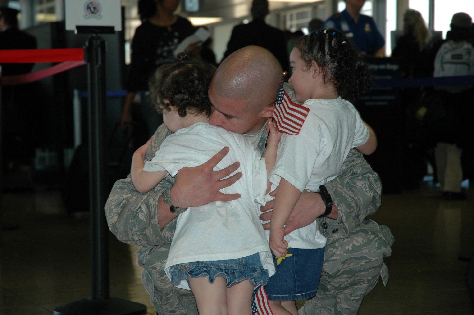 Staff Sgt. Francisco Alcocer, 944th Security Forces Squadron member, kisses his children Jan. 5 after returning from a six-month deployment to Kirkuk Regional Air Base, Iraq. Sergeant Alcocer and 36 other security forces members were welcomed home at Phoenix Sky Harbor International Airport following their activation in support of Operation Iraqi Freedom. (U.S. Air Force photo/Tech. Sgt. Susan Stout)