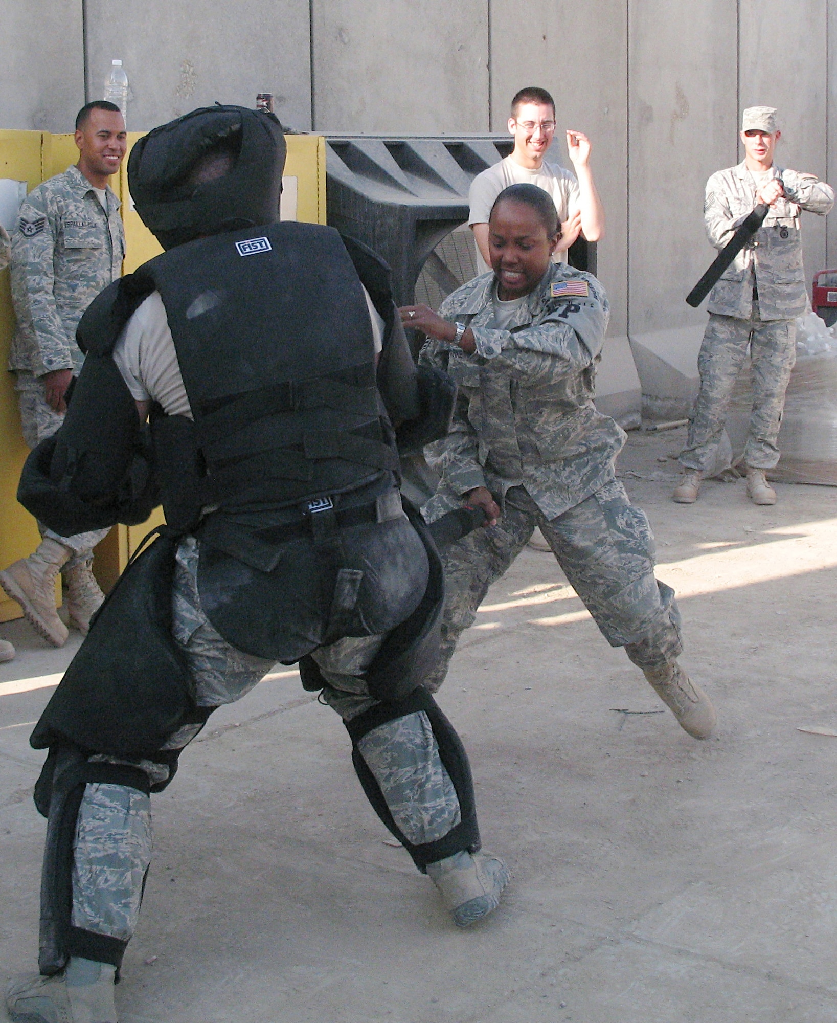 Senior Airman Shannon Parker uses nonlethal force to control an "adversary" and force him on the ground during a collapsible baton training practical Jan. 1 at Ali Base, Iraq. Airman Parker, a 407th Expeditionary Security Forces Squadron force protection augmentee, is deployed from the 59th Medical Wing at Lackland Air Force Base, Texas. (U.S. Air Force photo) 
