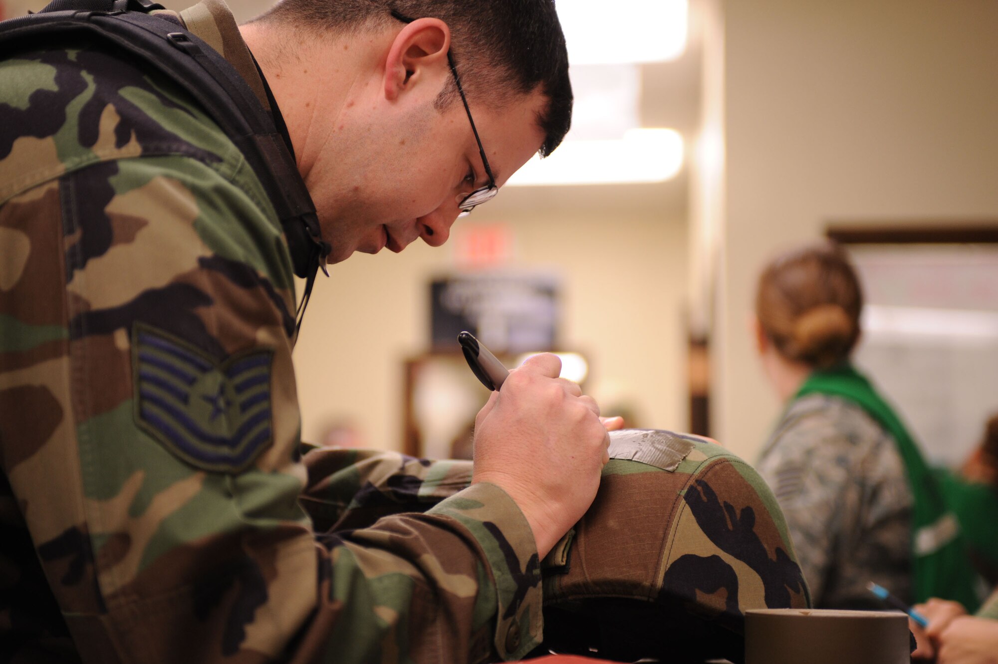 DYESS AIR FORCE BASE, Texas -- Technical Sgt. John Bailey, from the 7th Operations Support Squadron, properly labels his Kevlar helmet while processing through the personnel deployment function (PDF) line during the operational readiness inspection here, Jan. 6.  Making sure that all labels are filled out correctly is one of the many items checked while processing through the PDF line.  (U.S. Air Force photo by Staff Sgt. Darcie Ibidapo)