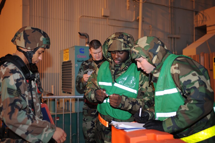 DYESS AIR FORCE BASE, Texas -- Airman 1st Class Michael Shakhtmeyster (right) and Senior Airman Rafael Mckensie (center), both from the 7th Force Support Squadron, check identification cards of deploying Airmen against the chalk passenger list prior to allowing them into the deployment control center to process through the personnel deployment function (PDF) line during the operational readiness inspection here, Jan. 6.  It is critical that Airmen process through the PDF line with their proper chalk to maintain accountability and prevent unnecessary personnel movement challenges.  (U.S. Air Force photo by Staff Sgt. Darcie Ibidapo)