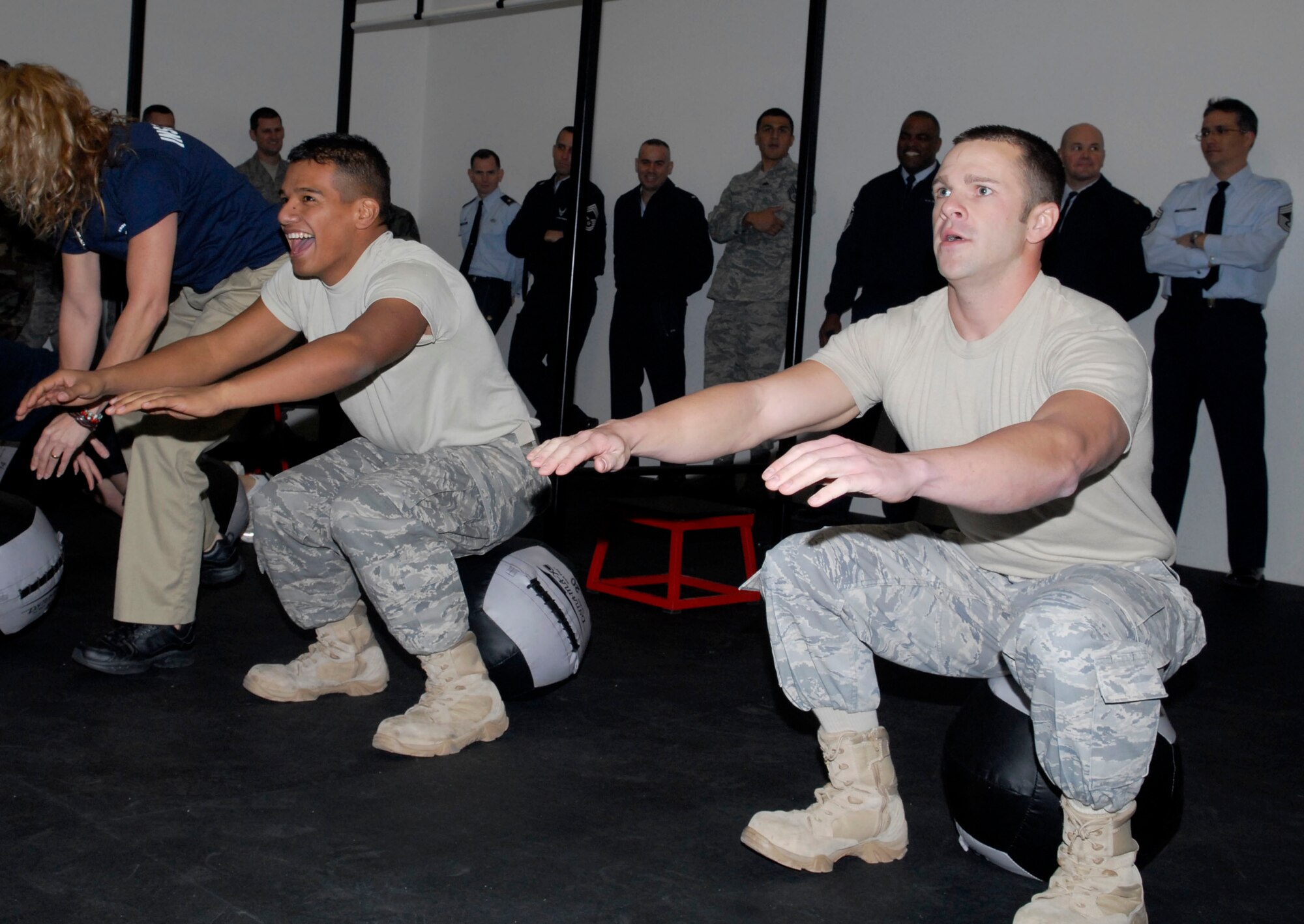 Airman 1st Class Johnny Chavez, left, and Staff Sgt Paul Shepherd , 56th Civil Engineer Squadron, perform squats during a five minute CrossFit Demonstration at the grand opening of the CrossFit gym on Jan. 5. The new CrossFit facility, located in building 700, offers CrossFit classes three times daily. (U.S. Air Force photo/Staff Sgt. Ian Dean)