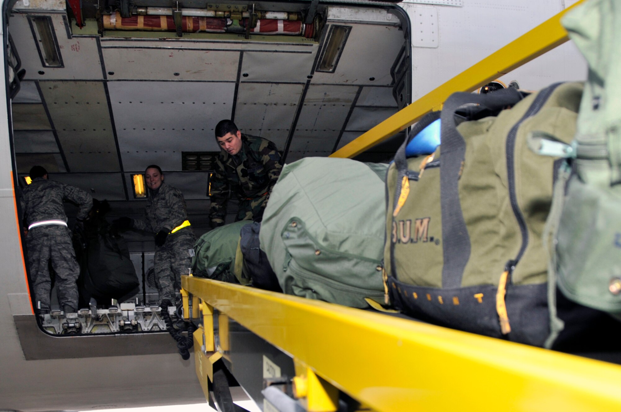 Airmen load luggage onto the MD-11, Jan. 3 at RAF Lakenheath, England. More than 300 Airmen from the 48th Fighter Wing deployed in support of Operation Enduring Freedom. (U.S. Air Force photo by Airman 1st Class Perry Aston)
