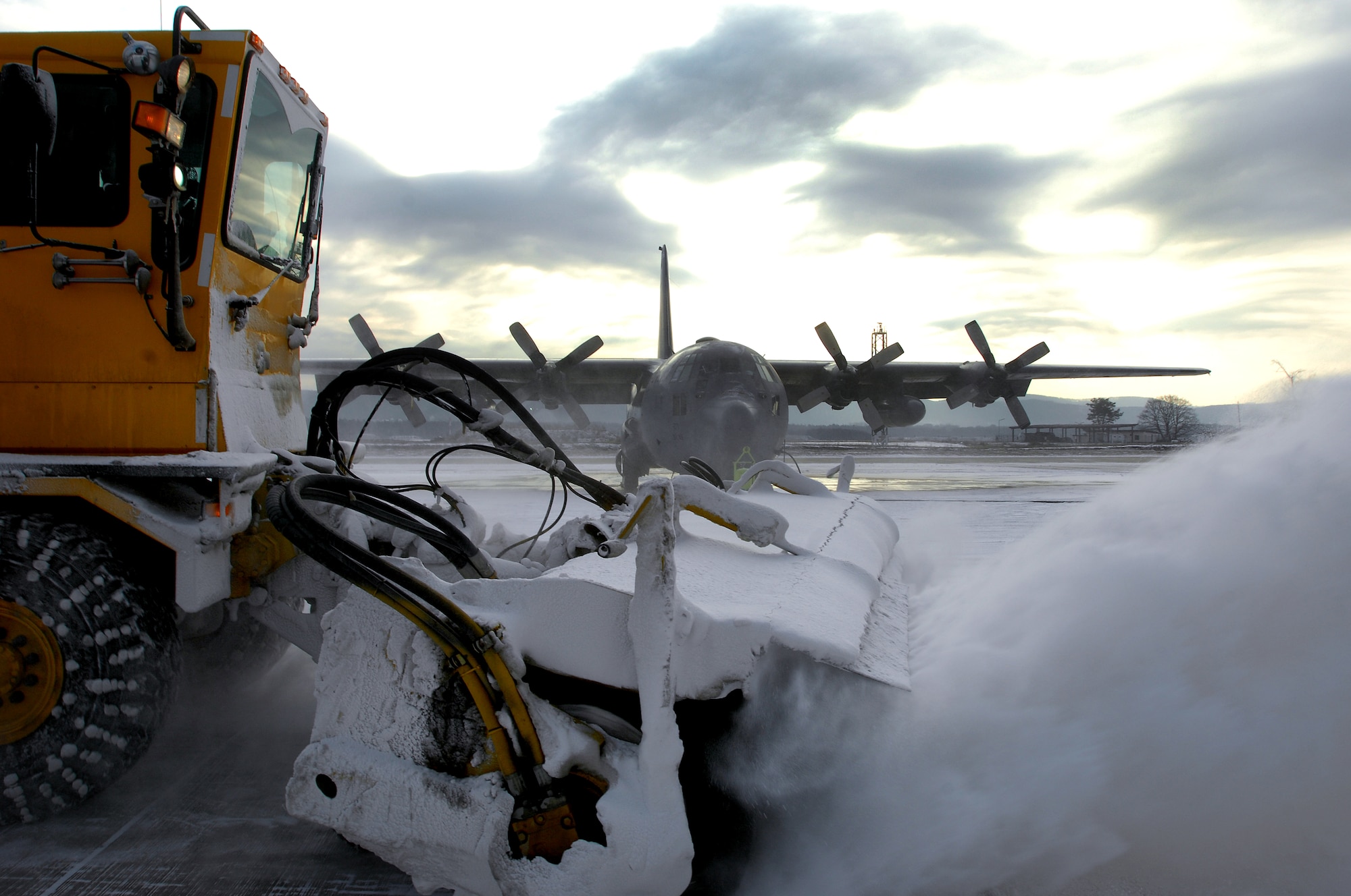 Members of Ramstein Air Field Management use a snow removal truck to clear snow off ramp one Jan. 6, 2008, before the day's mission. (U.S. Air Force photo by Airman 1st Class Kenny Holston)