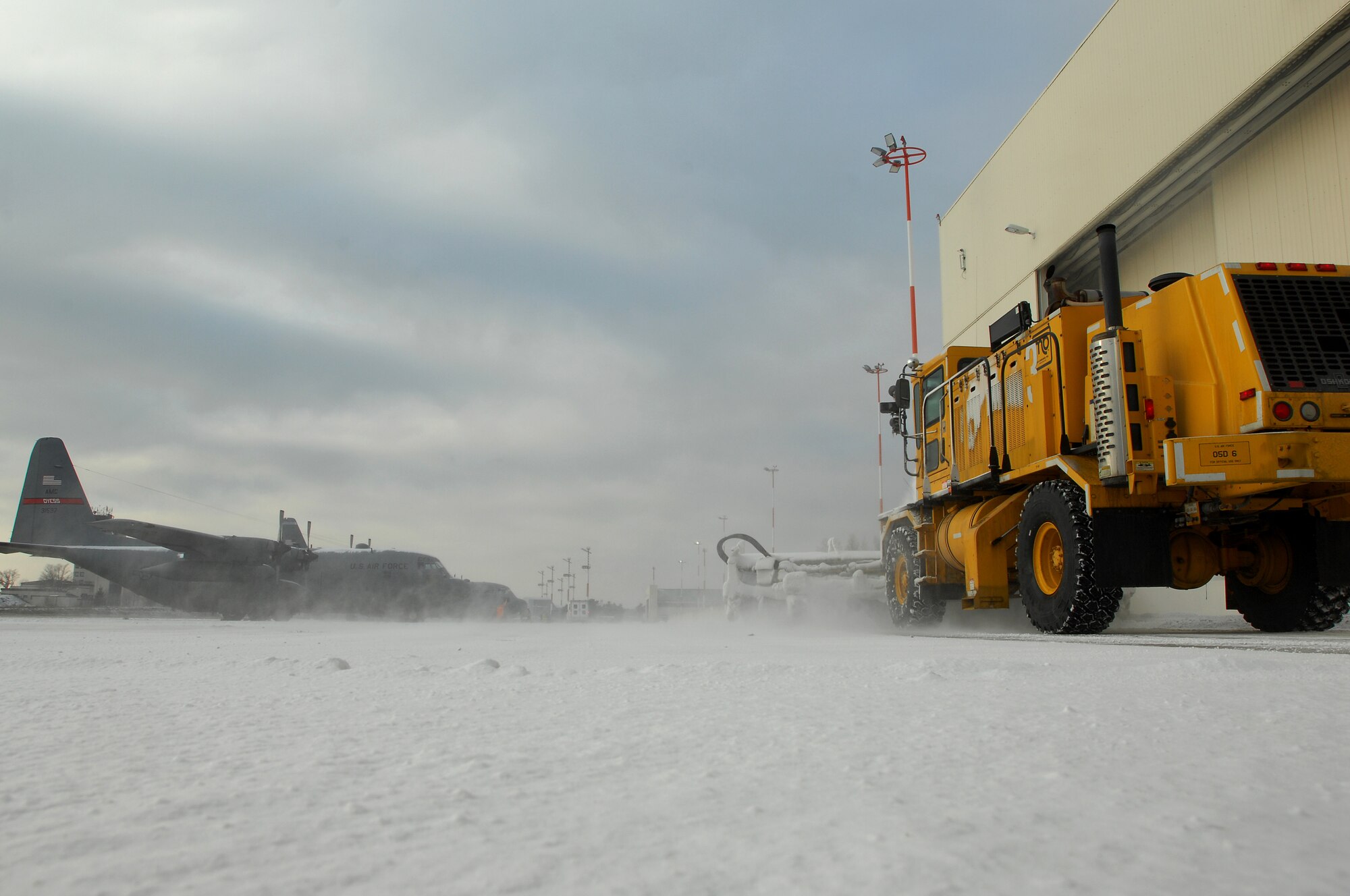 Members of Ramstein Air Field Management use a snow removal truck to clear snow off ramp one Jan. 6, 2008, before the day's mission. (U.S. Air Force photo by Airman 1st Class Kenny Holston)