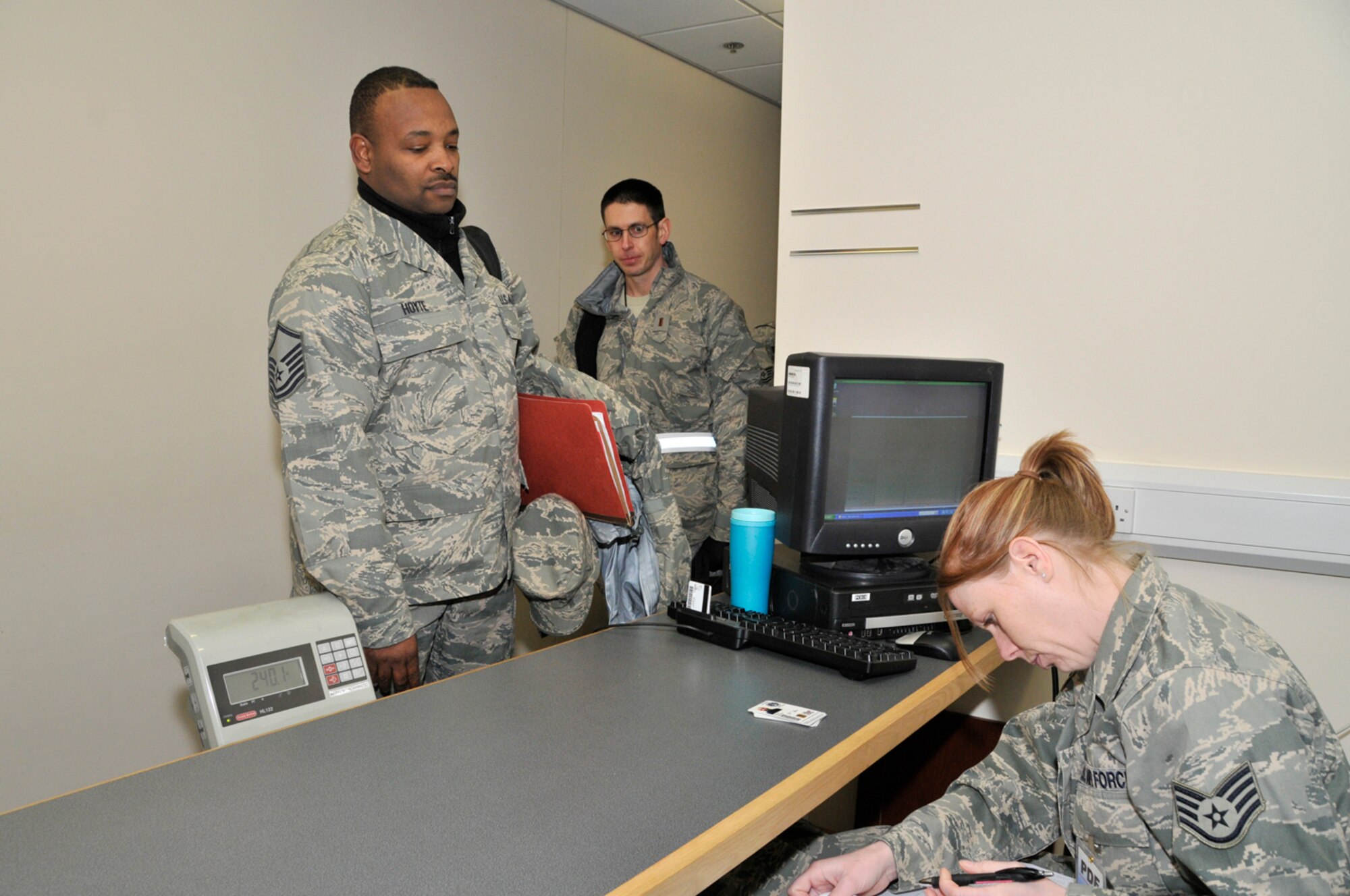 Master Sgt. Rodney Hoyte, 48th Air Craft Maintence Squadron, steps on a scale to weigh himself and his carry-on baggage Jan. 3 at RAF Lakenheath, England. Airmen and ther gear must be weighed to determine how much fuel will be needed for the flight. (U.S. Air Force photo by Airman 1st Class Perry Aston)