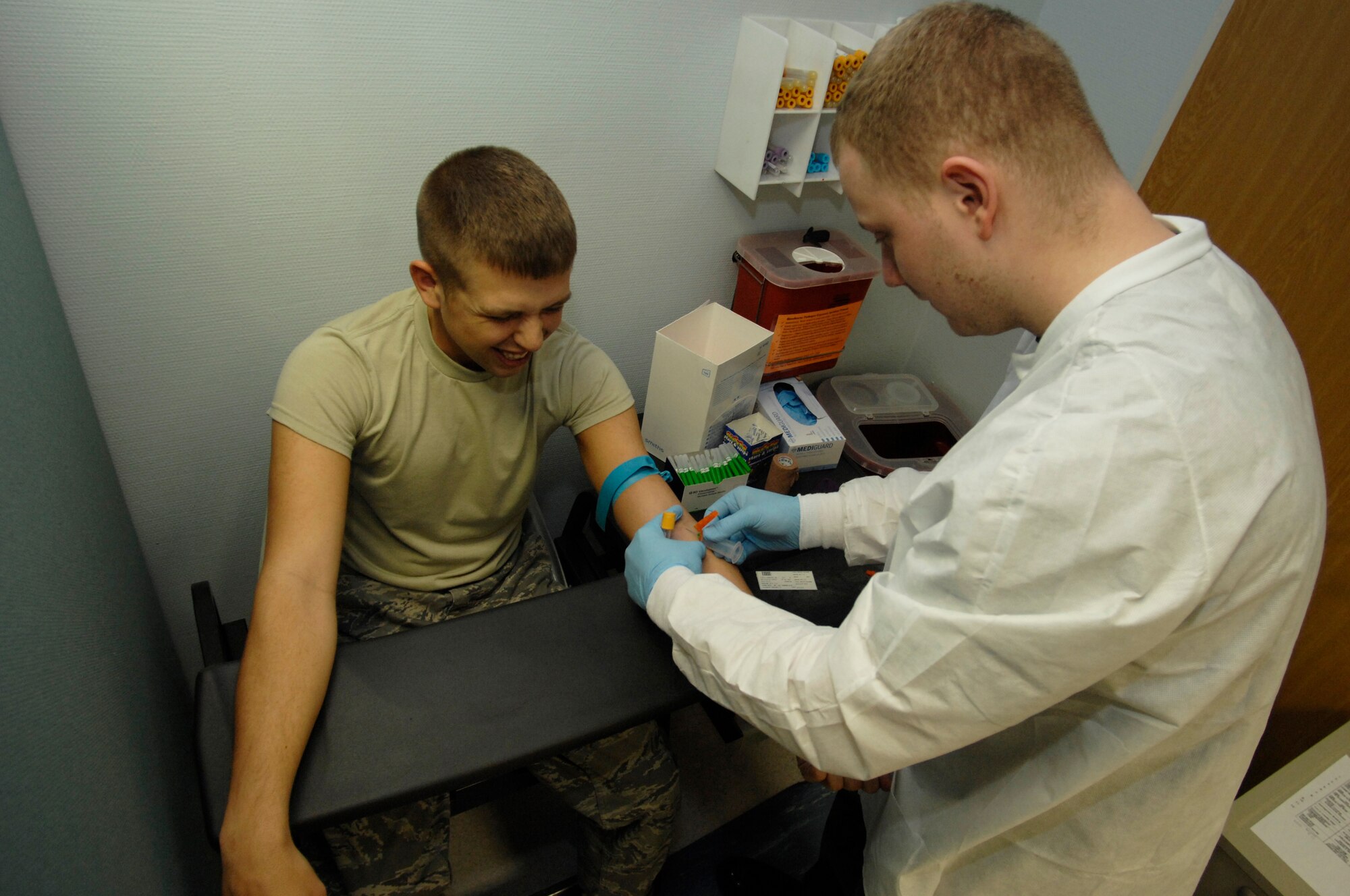 (Right) Staff Sgt. Robert Boles, 435th Medical Support Squadron medical laboratory journeyman, takes a blood sample from Airman 1st Class Derick Lyell, 435th Civil Engineer Squadron, at Ramstein Air Base Jan. 6, 2009. The laboratory keeps a blood sample on file for service members deploying out of Ramstein. (U.S. Air Force photo by Senior Airman Amber Bressler)