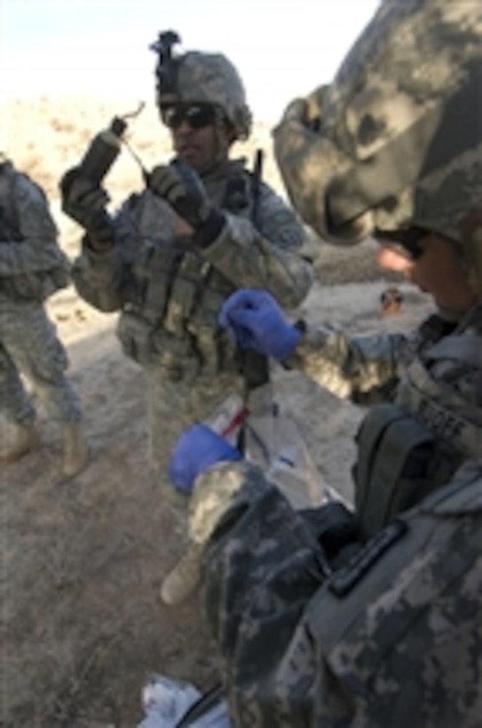U.S. Army Staff Sgt. Lashawn Lenore (2nd from right) and U.S. Navy Petty Officer 2nd Class Richard Ruoff take samples from items found in a weapons cache in Baqouba, Iraq, on Jan. 3, 2009.  U.S. soldiers from the Chemical, Biological, Radiation and Nuclear Weapons Intelligence Team Platoon, Brigade Troops Battalion, 1st Stryker Brigade Combat Team, 25th Infantry Division are moving to exploit a weapons cache found by fellow 25th Infantry Division soldiers while conducting a patrol.  